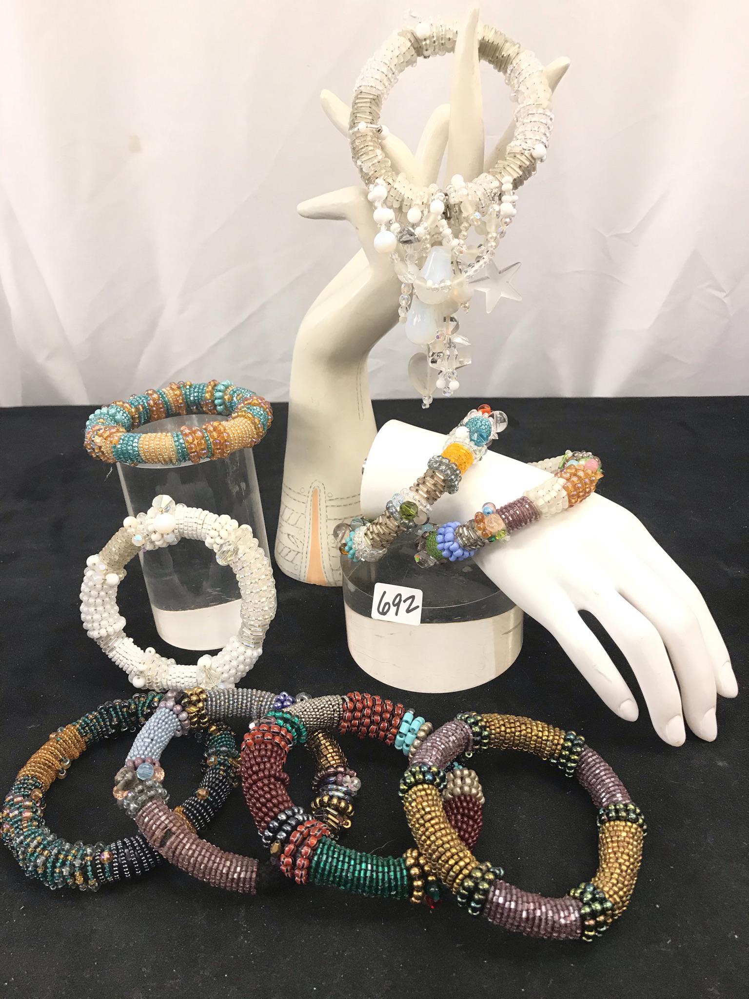 Group of 9 Hand Beaded Bangle Bracelets: This group of multicolored hand beaded bangle bracelets have glass beads, stones, and crystals.
