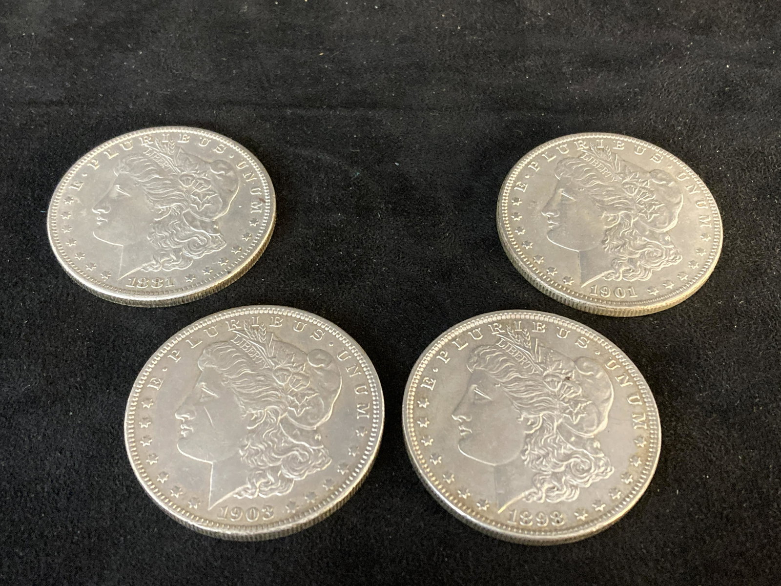 4 Morgan Silver Dollars: 4 Morgan silver dollars to include an 1881S, an 1898(no mint), a 1901O, and a 1903(no mint). Altogether, they weigh about 106.6 grams and are in good condition.