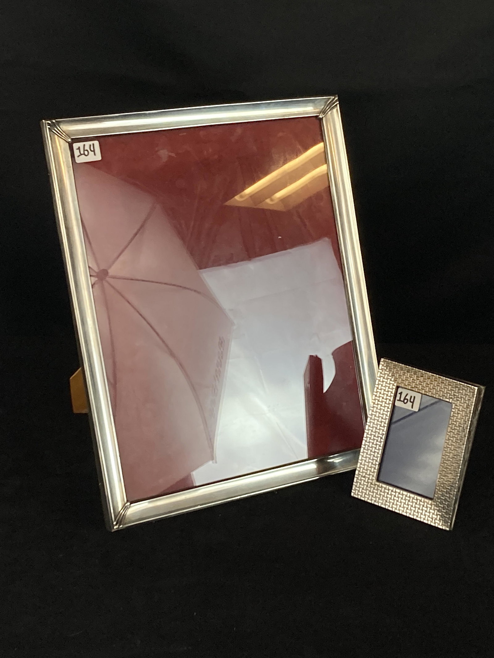 Silver Picture Frames: A large unmarked silver frame that measures 13.5" tall X 11" across and a smaller sterling frame that measures 5" tall X 4" across.