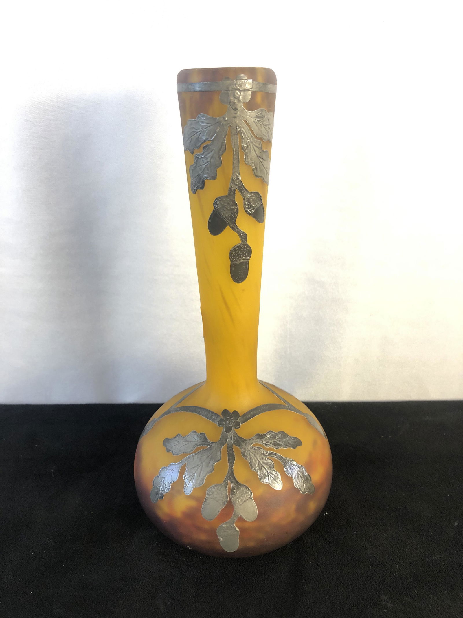 Muller Freres Luneville France Art Glass with Silver Overlay: A Muller Freres Luneville France art glass vase from the 1900's in yellows, oranges, and burgundy with silver overlay, oak leaves, and acorns. This artist signed quality piece of French art glass meas