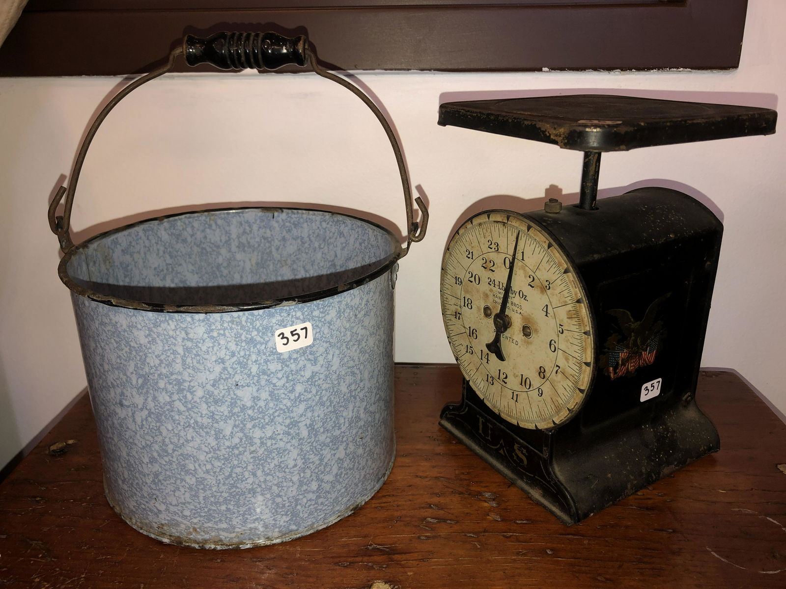 Scale with Eagle Stencling from 1899 and Blue Graniteware Pail: Lot of 2 items to include a blue graniteware pail with black wooden handle, pail contains decorative wooden eggs. Second item is an excellent black tin scale with stenciled eagle motifs on the sides a