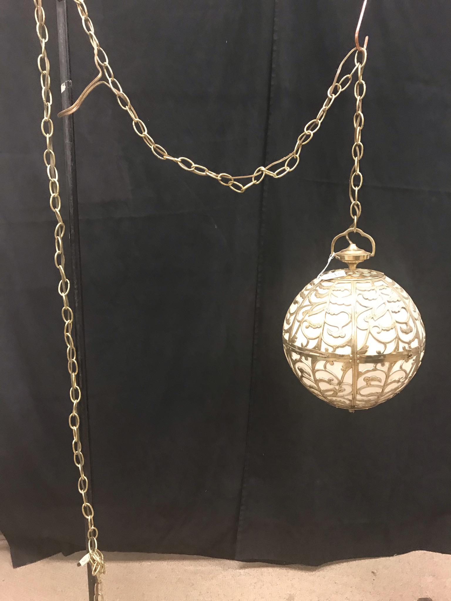 MCM Brass Swag Ball Lamp: This MCM 60's hinged case metal ball swag lamp has a serpentine cage like hinged ball shade and a switch on the cord. The ball measures 15" tall X 12" across.