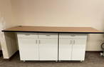 Large workbench tables with cabinet bases. Can be configured to fit needs - top pieces measure 34"