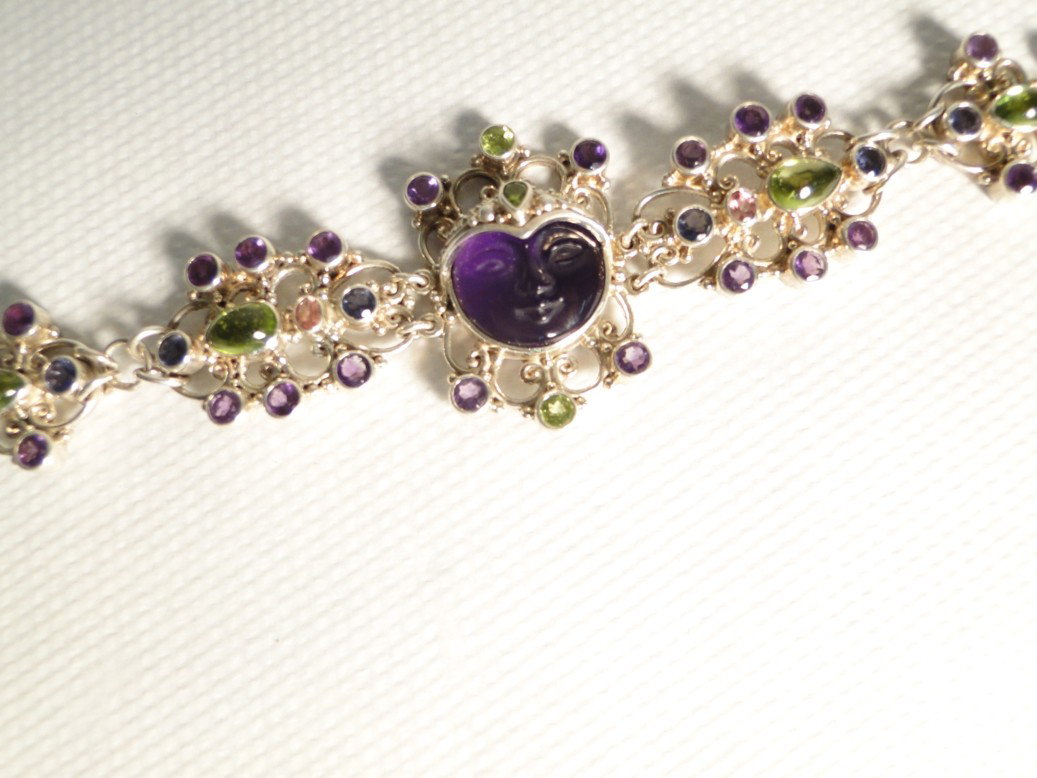 Balinese sterling filigreed bracelet with carved a: Balinese sterling filigreed bracelet with carved ameythst face stone in the center and other ameythst and semi-precious stones on the sides. This sterling silver bracelet with stones weighs 41 grams. 
