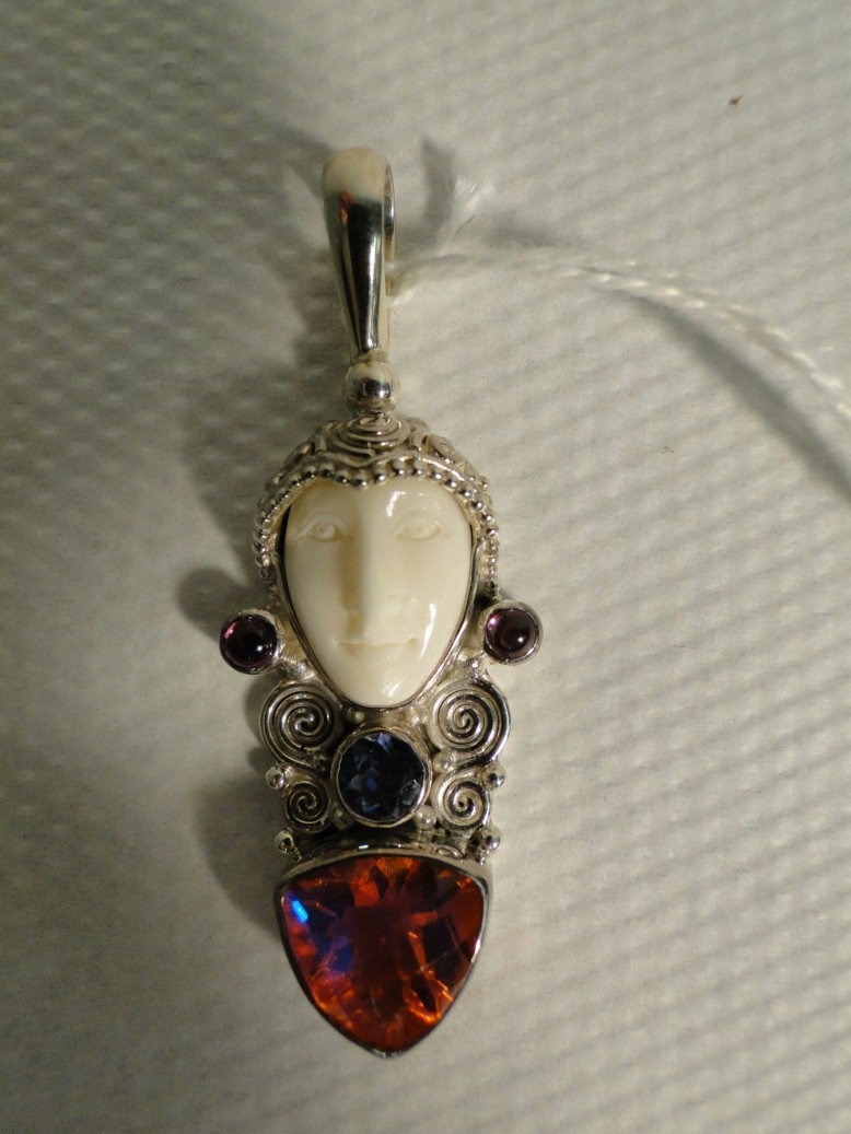 Sterling silver Balinese pendant with carved bone : Sterling silver Balinese pendant with carved bone face and large cushion cut treated topaz, with ameythst. Weighs 10 grams with stones. Est.value $100-175