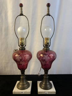 Early Victorian Ruby Wheelcut Glass Lamps: A pair of ruby wheelcut glass and marble base table lamps. They date to the mid 1800s and were originally oil lamps that have been electrified. They each measure 23.5" tall with harp or 14.5" without.