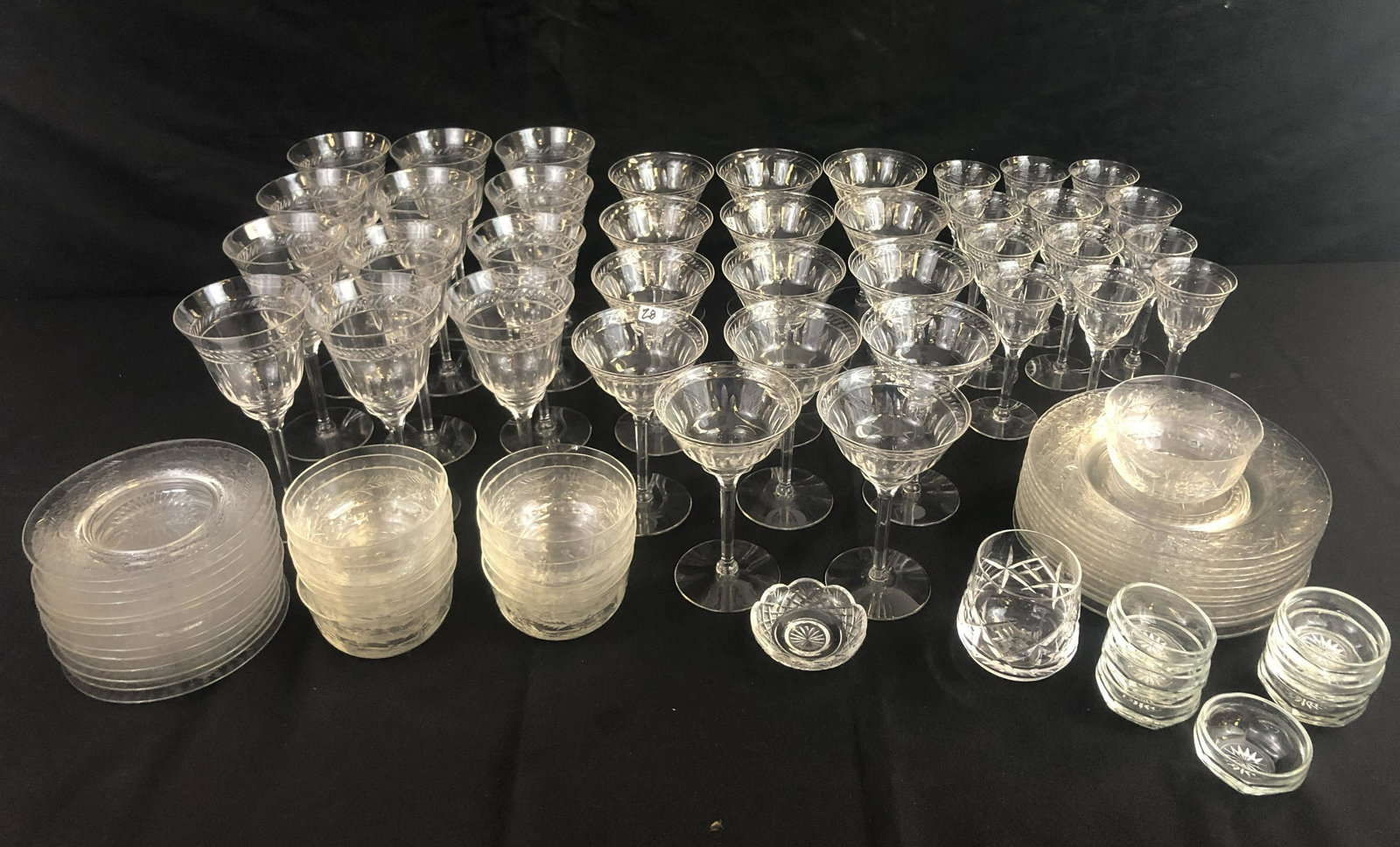 Set of 1920s Crystal Stemware and Plates: A set of high quality glass stemware to include 12 water goblets, 14 wine glasses and 12 cordial glasses. One of the cordials is slightly smaller than others, may have been cut down at some point. Als