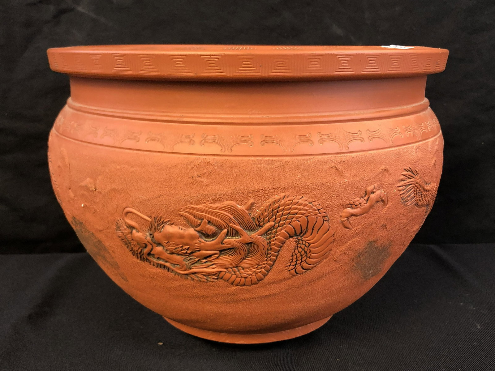 Terra Cotta Jardinaire: A terra cotta oriental jardinaire with dragon decoration that appears to have age. This piece measures 9" tall X 13.5" across.