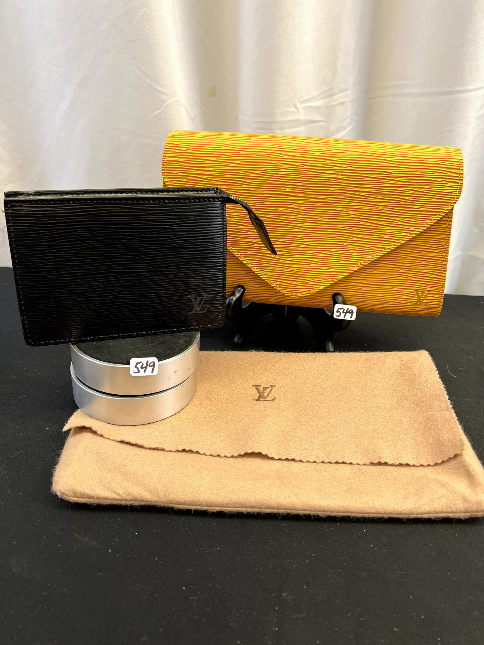 Louis Vuitton Epi Leather clutch and Zip Bag: This group of Louis Vuitton bags include a weather resitant Epi leather embossed clutch in goldenrod yellow clutch with an eggplant colored interior, its original dust bag, a monogrammed corner, and b