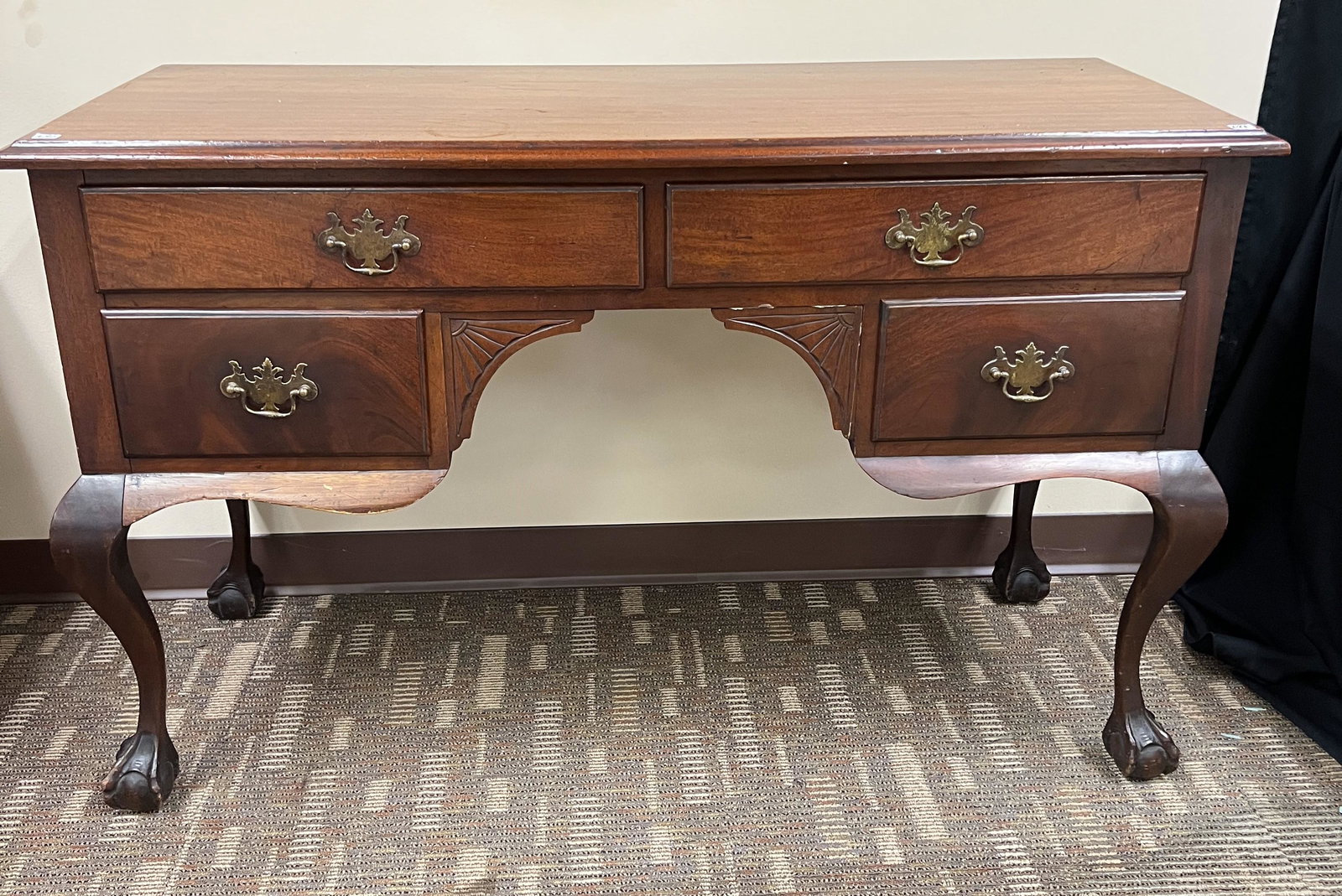 Turn-of-the-Century Mahogany Four-Drawer Desk: A turn-of-the-century mahogany claw-foot four-drawer desk. It has a fake front on the other side It meaures 30" tall X 48" across X 20" deep.