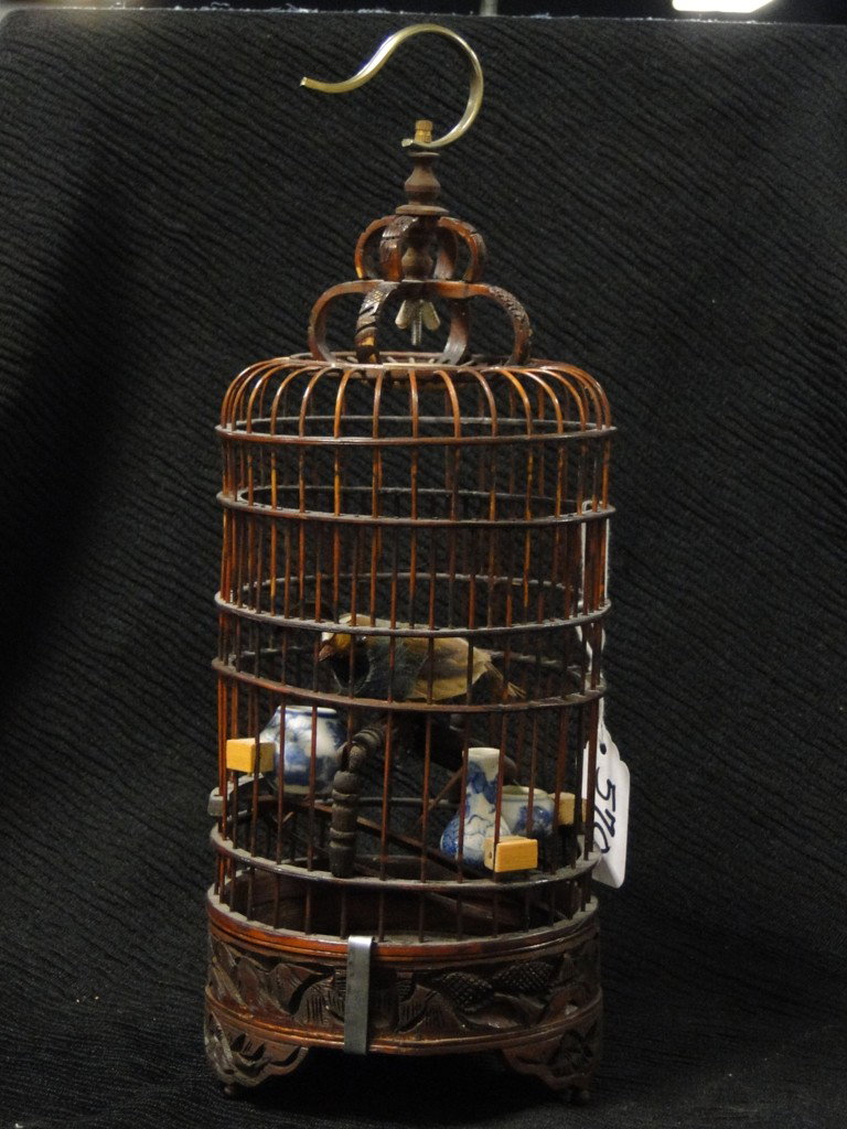 An outstanding hand carved Oriental cricket or bir: An outstanding hand carved Oriental cricket or birdcage, artist signed on bottom with stone insert and elaborate blue and white bowl feeders; 12"H; Est. Value $150-$250