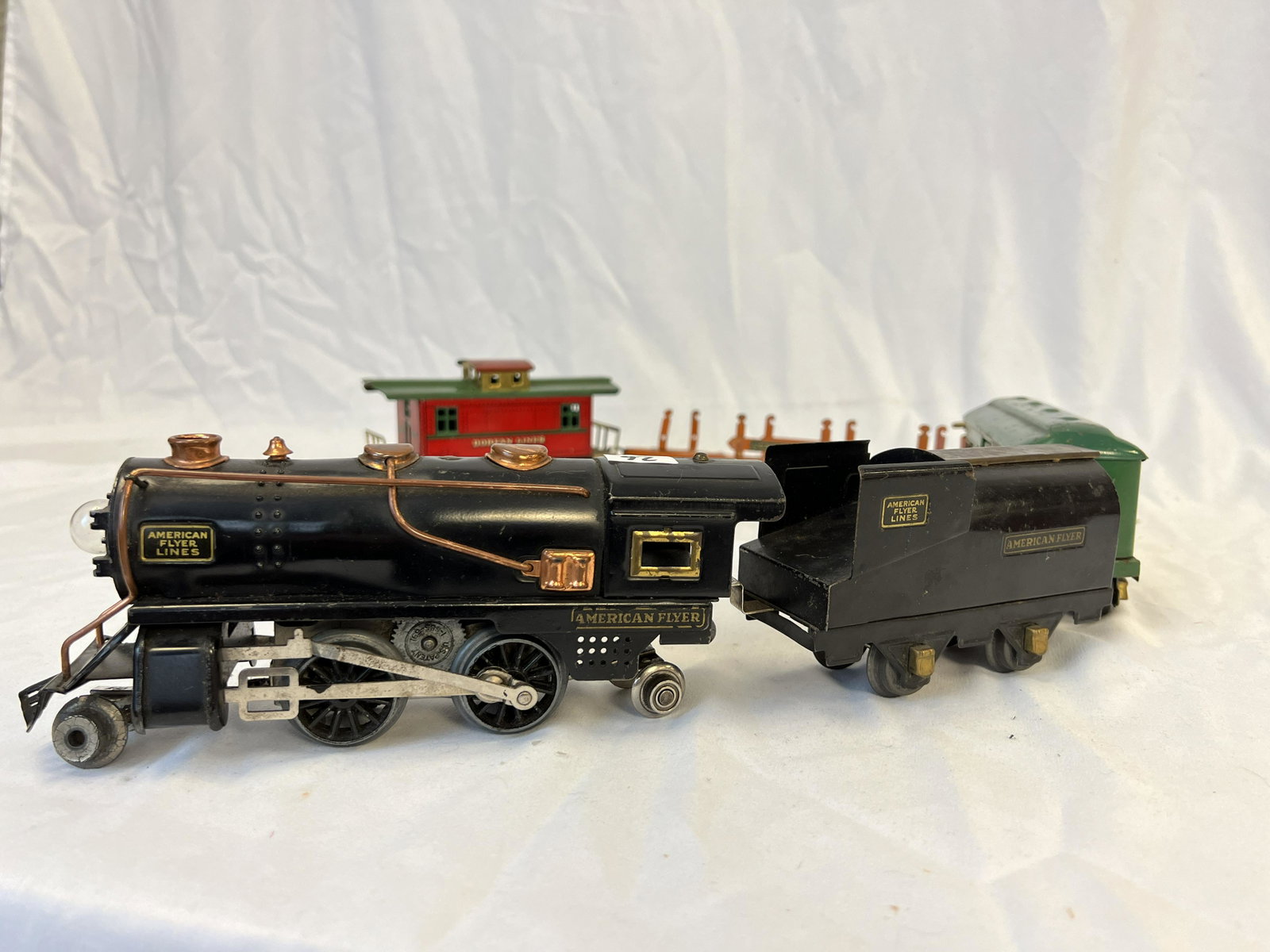 Complete American Flyer Train with Cars: A complete American Flyer train with cars to include engine, coal car, mail car, flat bed car, and caboose with good original paint. Needs Cleaning.