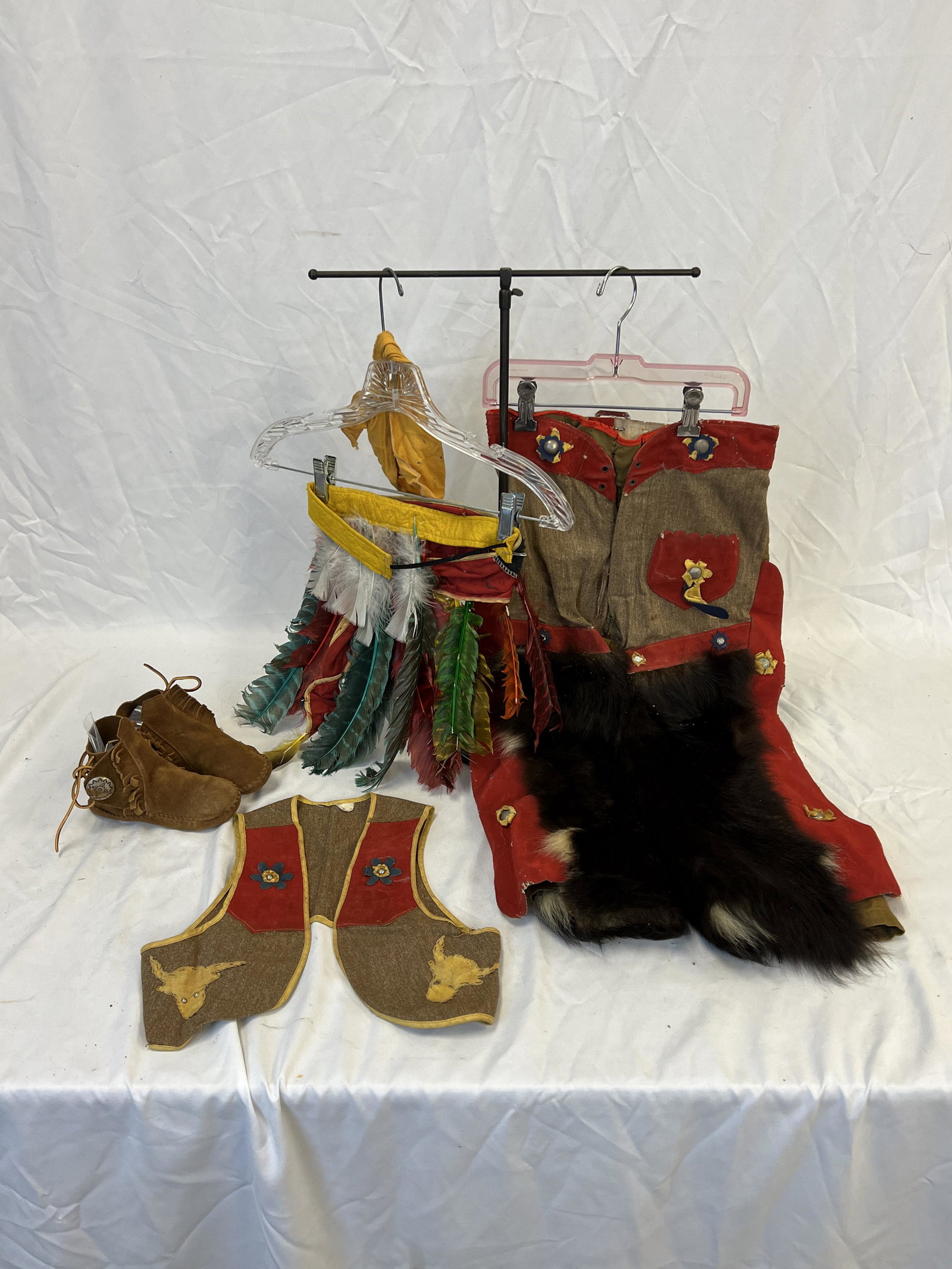 Child's Cowboy Outfit & Headdress: Child's cowboy pants, vest, and moccasins with silver conches, and a child's Native American headdress.