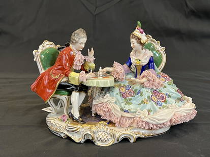 Dresden-Meissen Chess Figurine: A Dresden-Meissen figural grouping of a man and woman playing chess. Minor losses to woman's elaborate skirt. Blue crown mark on bottom. It measures 9.5" across X 6" deep X 7.25" tall.