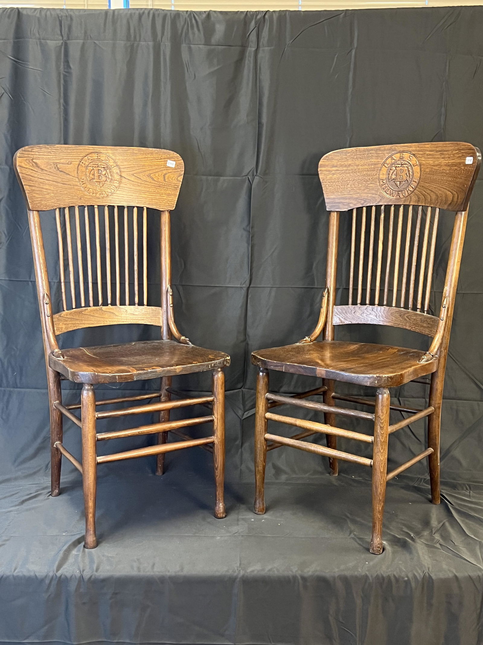 Pair of Pabst Tavern Chairs w/ Pabst Logo: 2 Pabst tavern chairs with deeply-pressed Pabst logo that reads "Pabst Milwaukee" with letter "B" with hops center. These turn-of-the-century ashwood chairs are in good condition and measure 40" tall