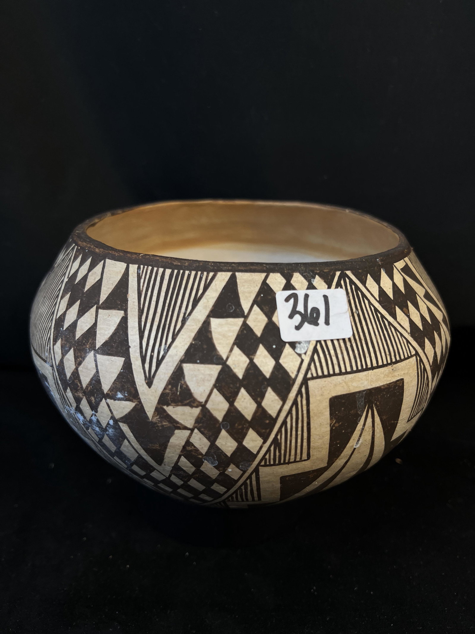 Acoma Pueblo Handmade Pot: A handmade and painted Acoma Pueblo New Mexico pot. This piece of pottery is beautifully painted with feather and geometric designs. This piece likely dates from 1900-1920. The pot is unsigned but is 