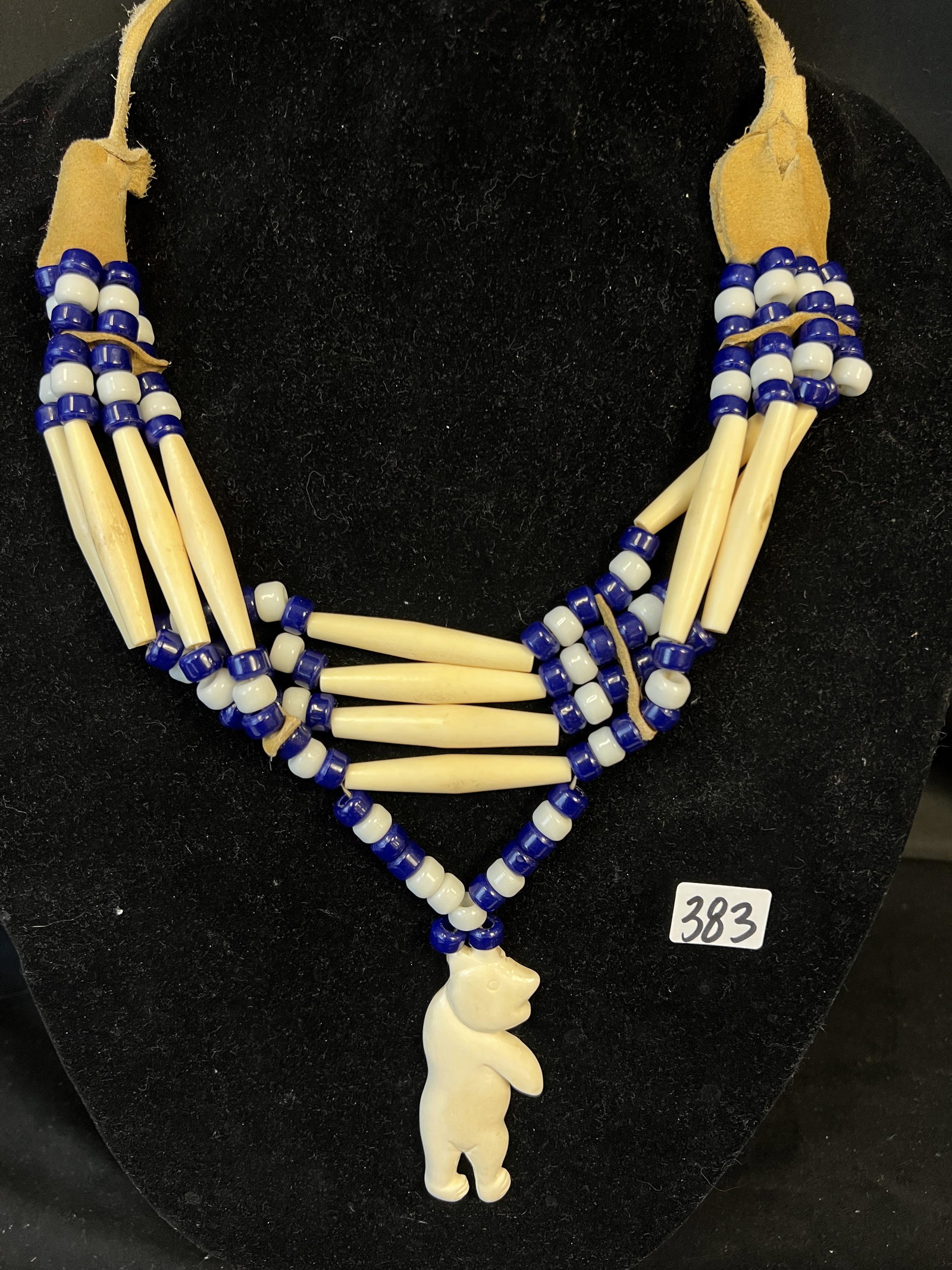 Inuit Choker with Carved Bone Polar Bear: An authentic hand made Inuit choker necklace featuring a bone carved polar bear with beadwork in bone, blue beads and white beads. Top of choker is adjustabel and is made out of hide. This wonderful c