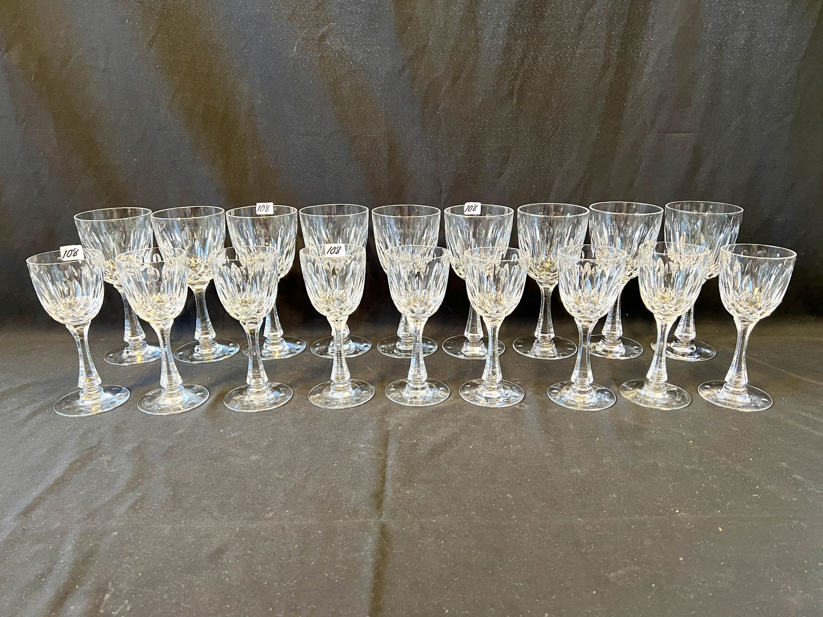 Set of Signed Hawkes Stemware: A set of quality cut and zippered cut Hawkes stemware consisting of 9 water goblets and 9 wine glasses. Originally from the Herman and Claudia Uihlein Mansion.