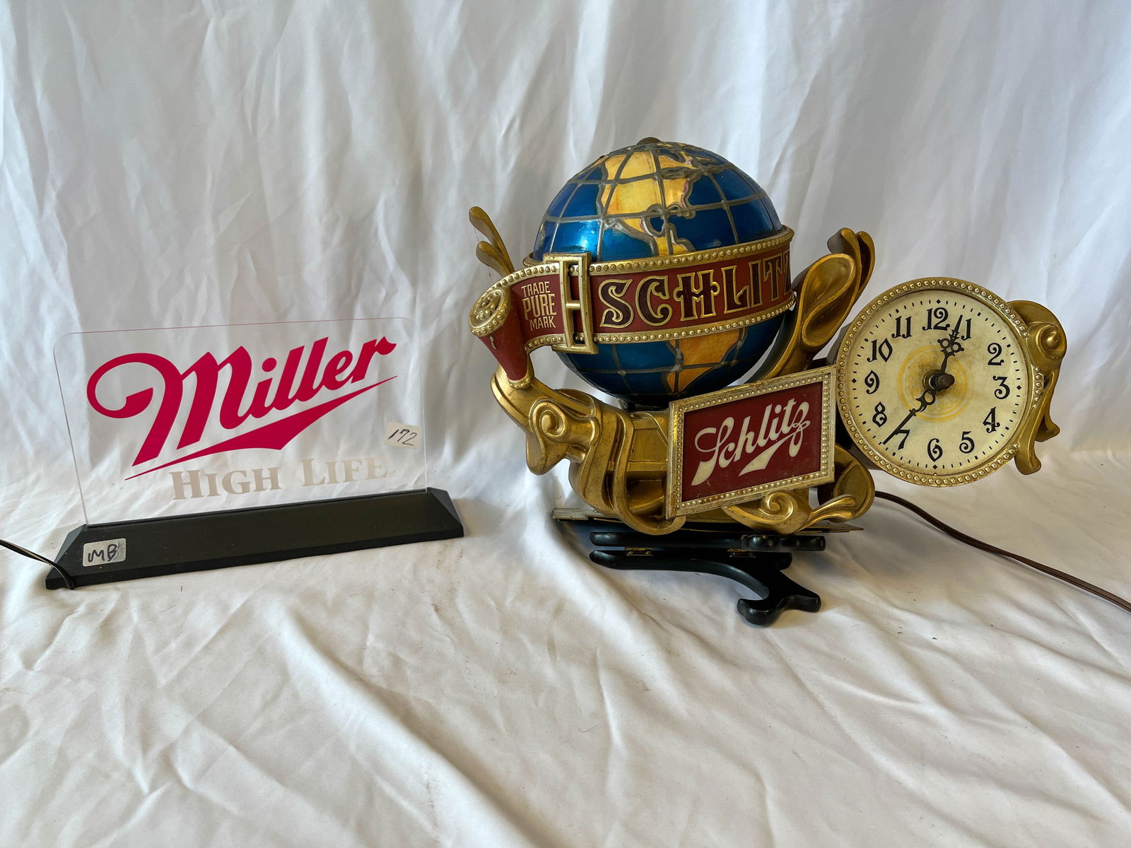 A Miller Highlife light up bar sign along with a Schlitz clock (1 of 3)