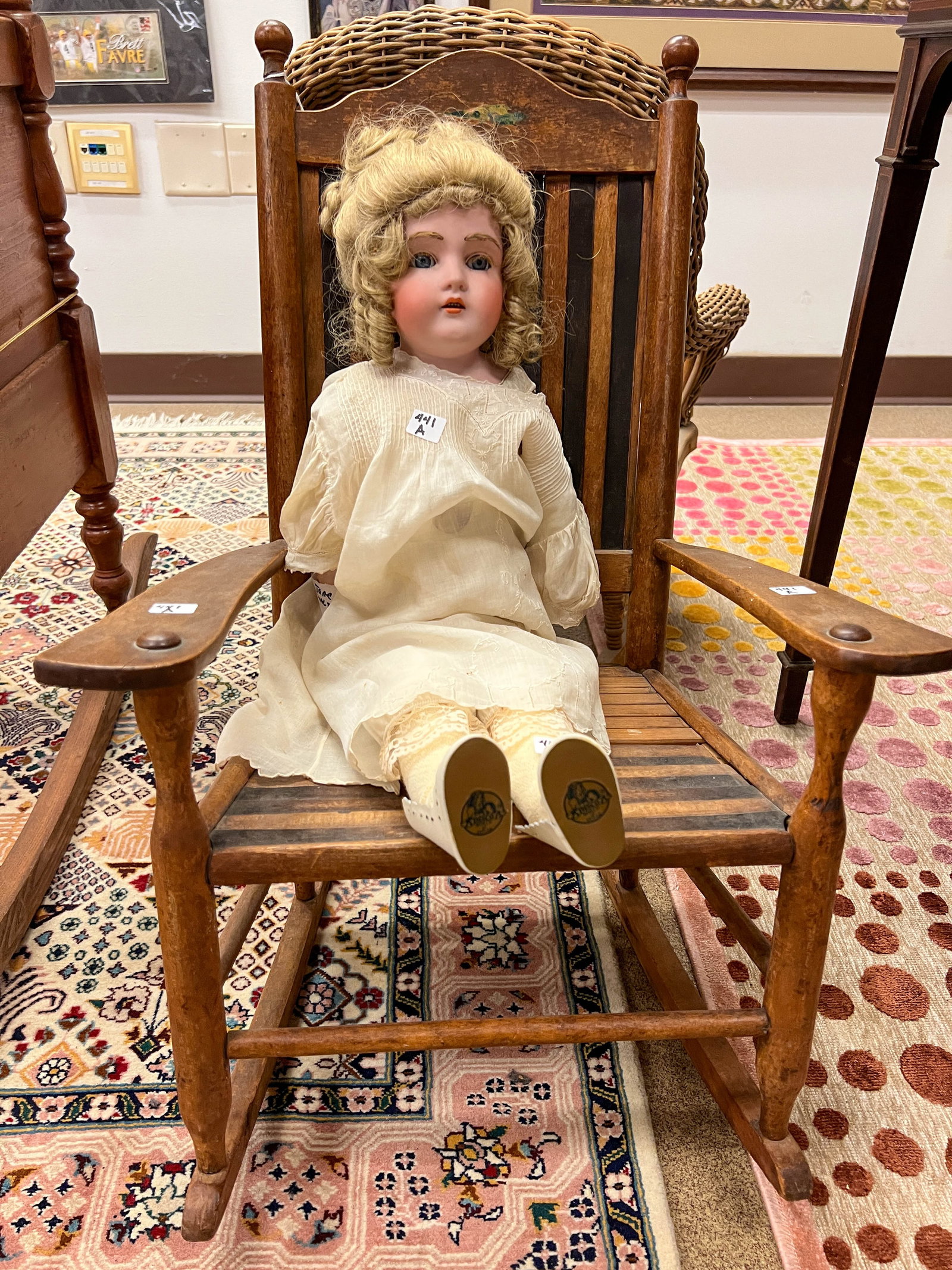 Bisque head doll with sleep eyes open mouth kid body in an antique child's rocking chair: Bisque head doll with sleep eyes open mouth kid body in an antique child's rocking chair