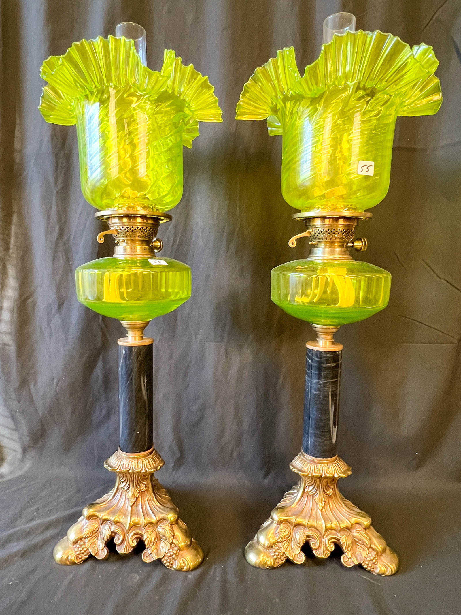 A Pair of Victorian Vaseline Banquet Lamps with Ruffle Shades: A pair of Victorian Vaseline banquet lamps with elaborate grape vine bases and marble posts, Vaseline crystalline and font and shades with elaborate ruffle edge. Signed, this stunning pair of Vaseline