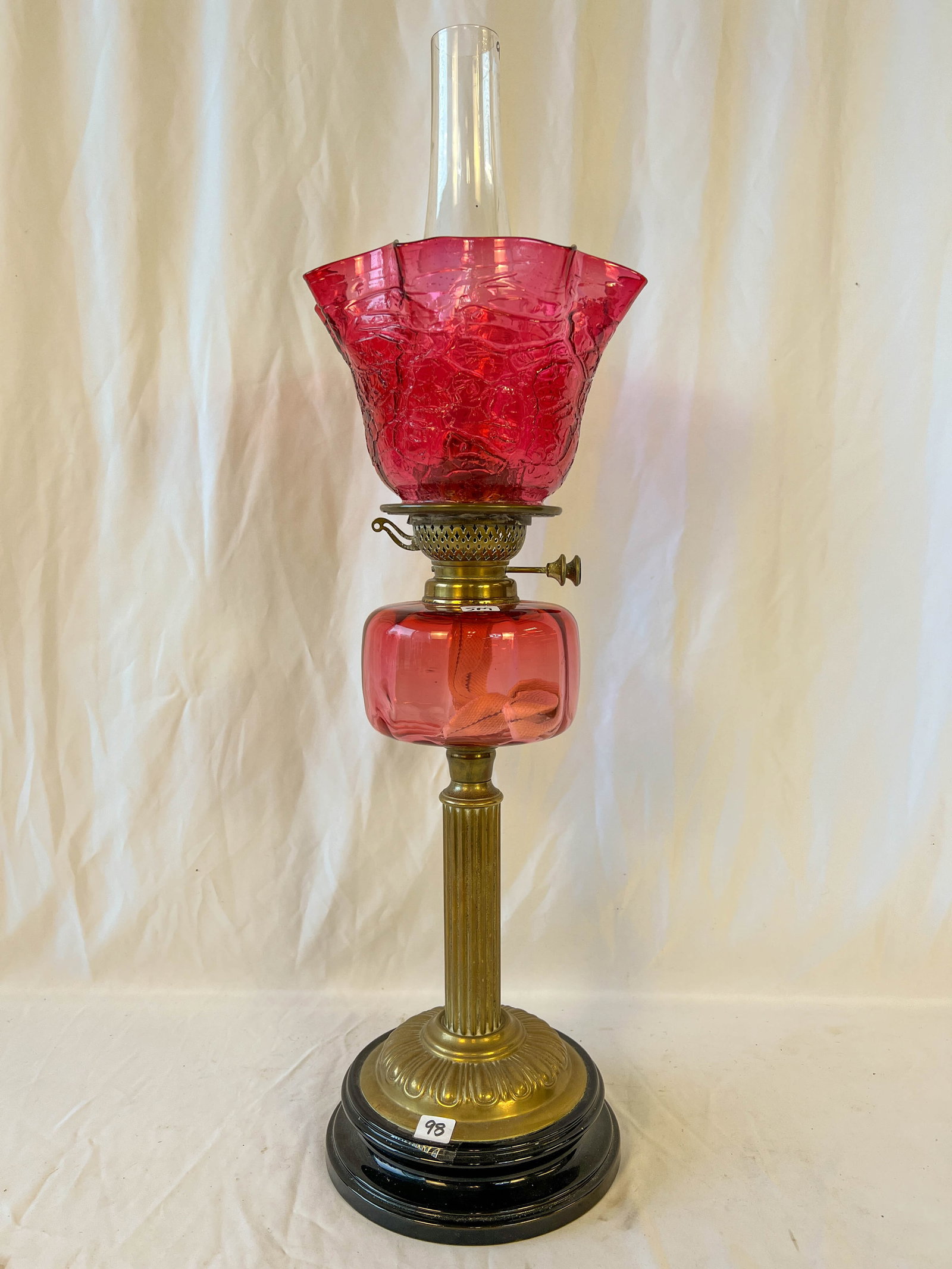 Rare Cranberry Amberina Oil Lamp: Cranberry oil lamp with lacquered base to brass stem to cranberry font and shade. Manufactured by Screw Youngs No.1; Measures 22" tall