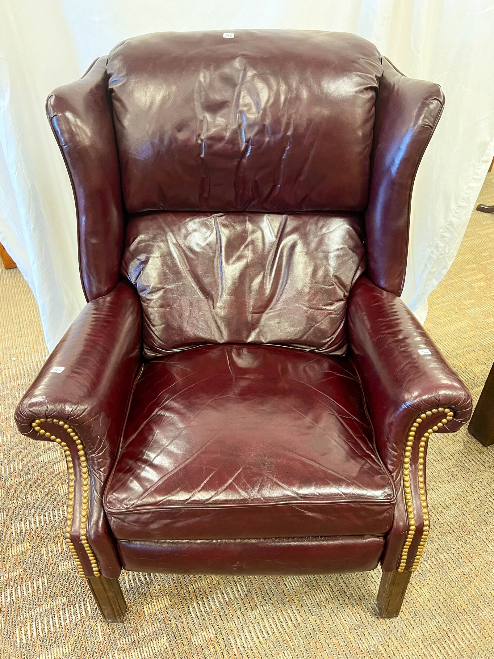 Reclining Cordovan Leather Chair with Brass Tack Trim: Reclining cordovan leather chair with brass tack trim nailheads. Measures 42" tall by 33" wide by 31" deep