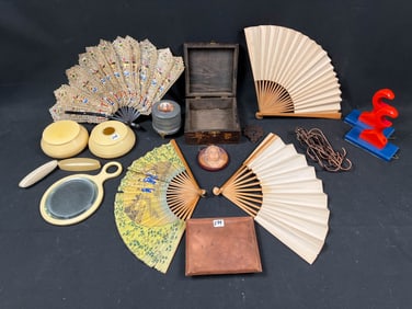 A mixed lot to include fans, celluloid make up containers and a small music box in working