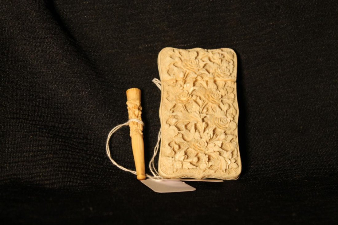 Heavily carved antique ivory card case. Measures 3: Heavily carved antique ivory card case. Measures 3-3/4" x 2-1/4" wide, floral motif. Along w/ an antique carved ivory cigarette holder also elaborately carved. Est. value $350-450
