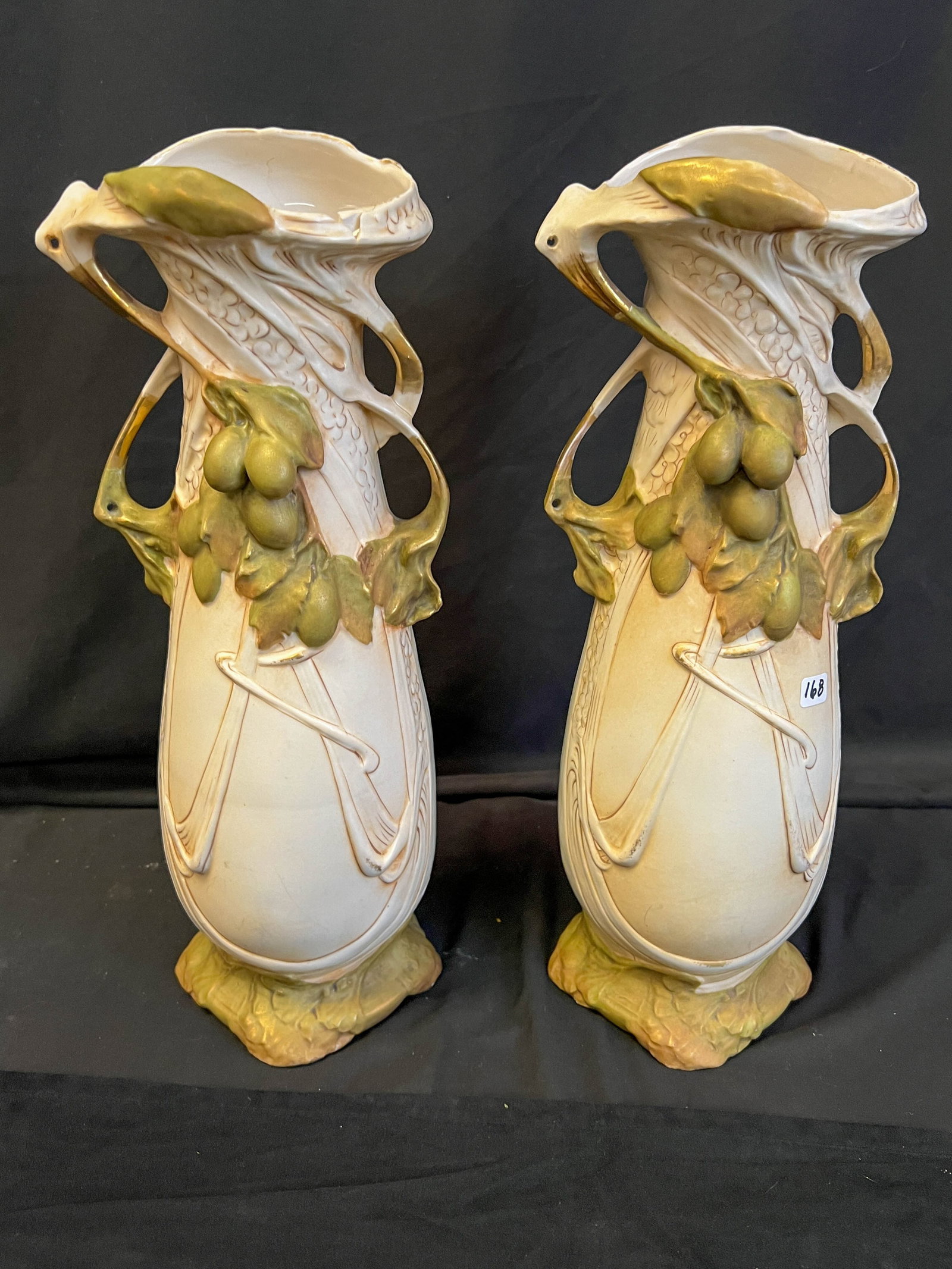 Royal Dux Art Nouveau Mantle Vases, Pair: This pair of Art Nouveau Royal Dux mantle vases feature an olive motif in green with green leaves and gilding on a matte beige field. They each measure 16" tall X 6" across X 6" deep. One vase is in e