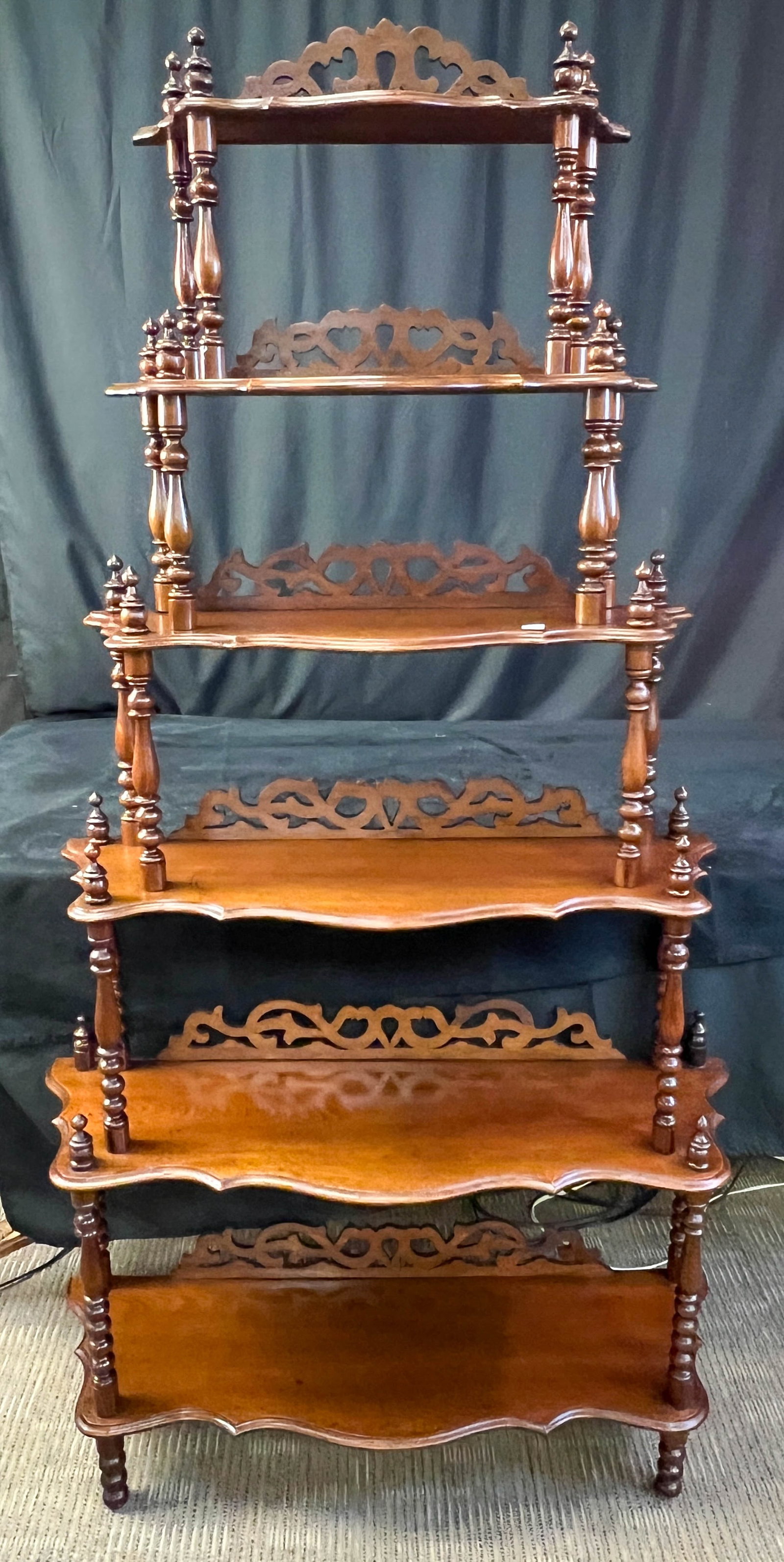 Antique Walnut Graduated 5 Tiered Eteger: This anitique walnut graduated 5 tiered eteger has a serpentine edge, back scrolling and turned spindles. In As found , good condition, it measures 64" tall X 34" across, by 11" deep.