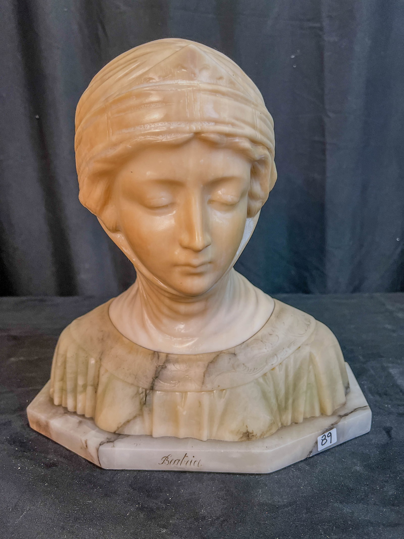 Marble Bust of Beatrice C. 1890s: An outstanding marble bust of Beatrice from the 1890s, piece is likely from the Italian school. Base and shawl of the marble statue feature heavy veining, the statue measures 14" tall X 14" across X 6