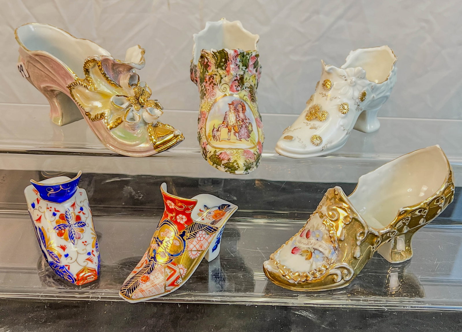 Group of 6 Antique Hand Painted Porcelain Shoes: A group of 6 antique hand painted Victorian shoe figurines. Shoes include Imari, molded floral and more. One Imari shoe has chip on side.