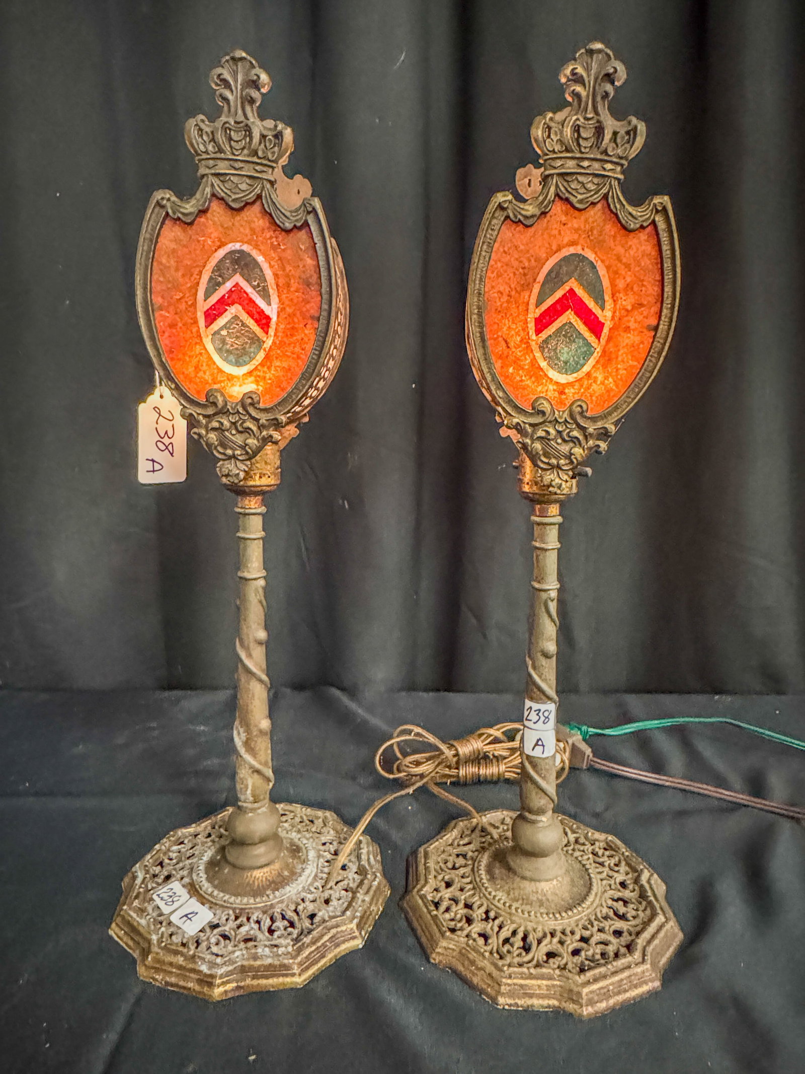 Pair of 1920's Mantle Lights: A matched pair of 1920s mantle lights with shield and crown design. Base of lamps is reticulated metal, overall a lovely pair of lamps.