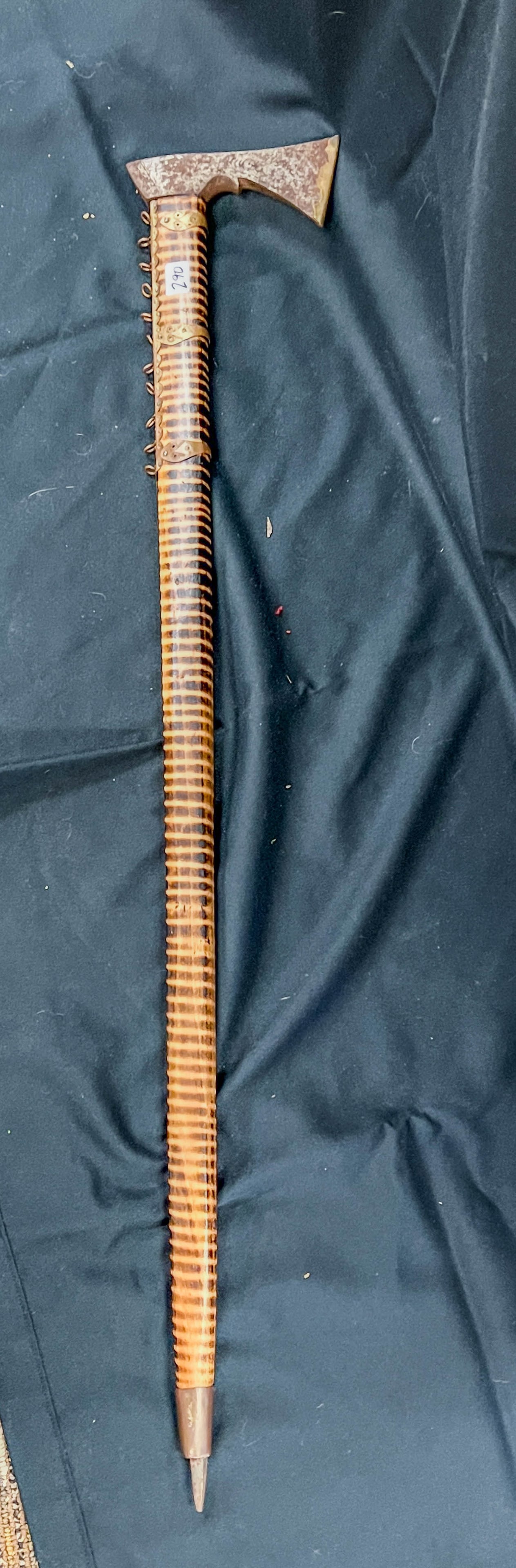 Tomahawk Walking Stick Circa 1890/1900: An antique Tomahawk made into a walking stick. Head of Tomahawk is elaborately chased, was later made into a walking stick. There is brass ornamentation on the stick on applied to the Tomahawk blade. 