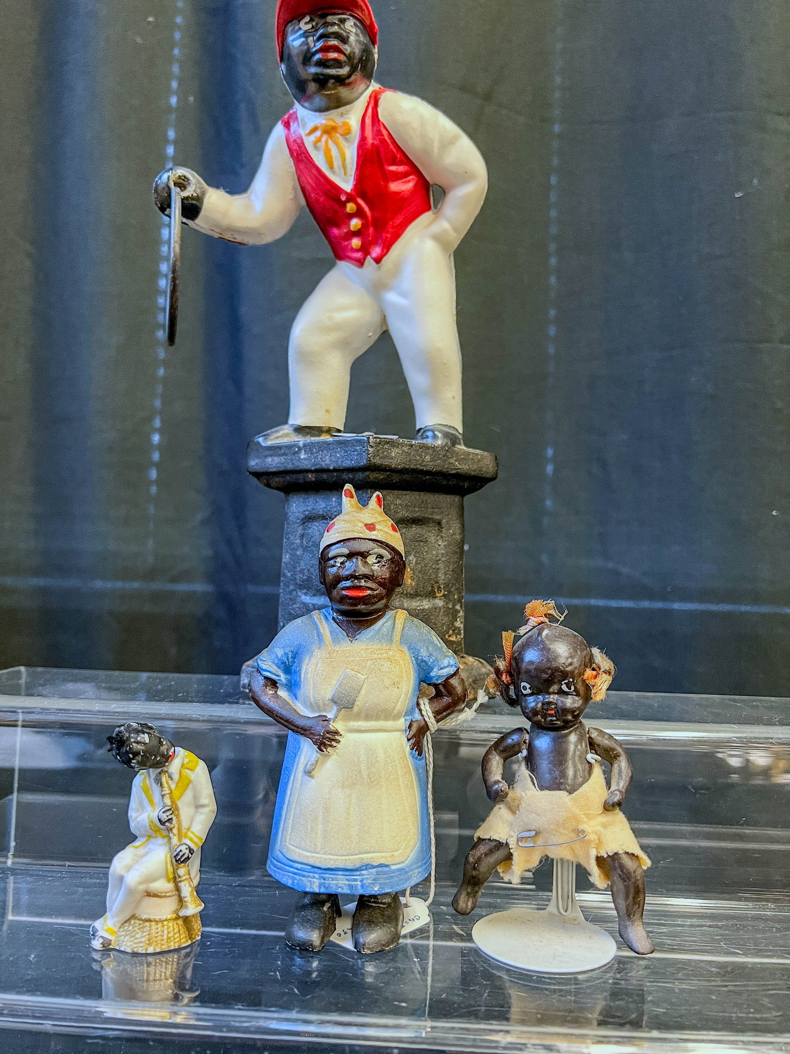 Black Americana Toys to include Bank, Doll, More!: This group of 20th Century Black Americana toys include a 1930's Cast Iron Mammy bank (6" tall), a 5" tall bisque jointed baby doll, and a 1920's bisque bobble head jazz clarinet player (3" tall) and 