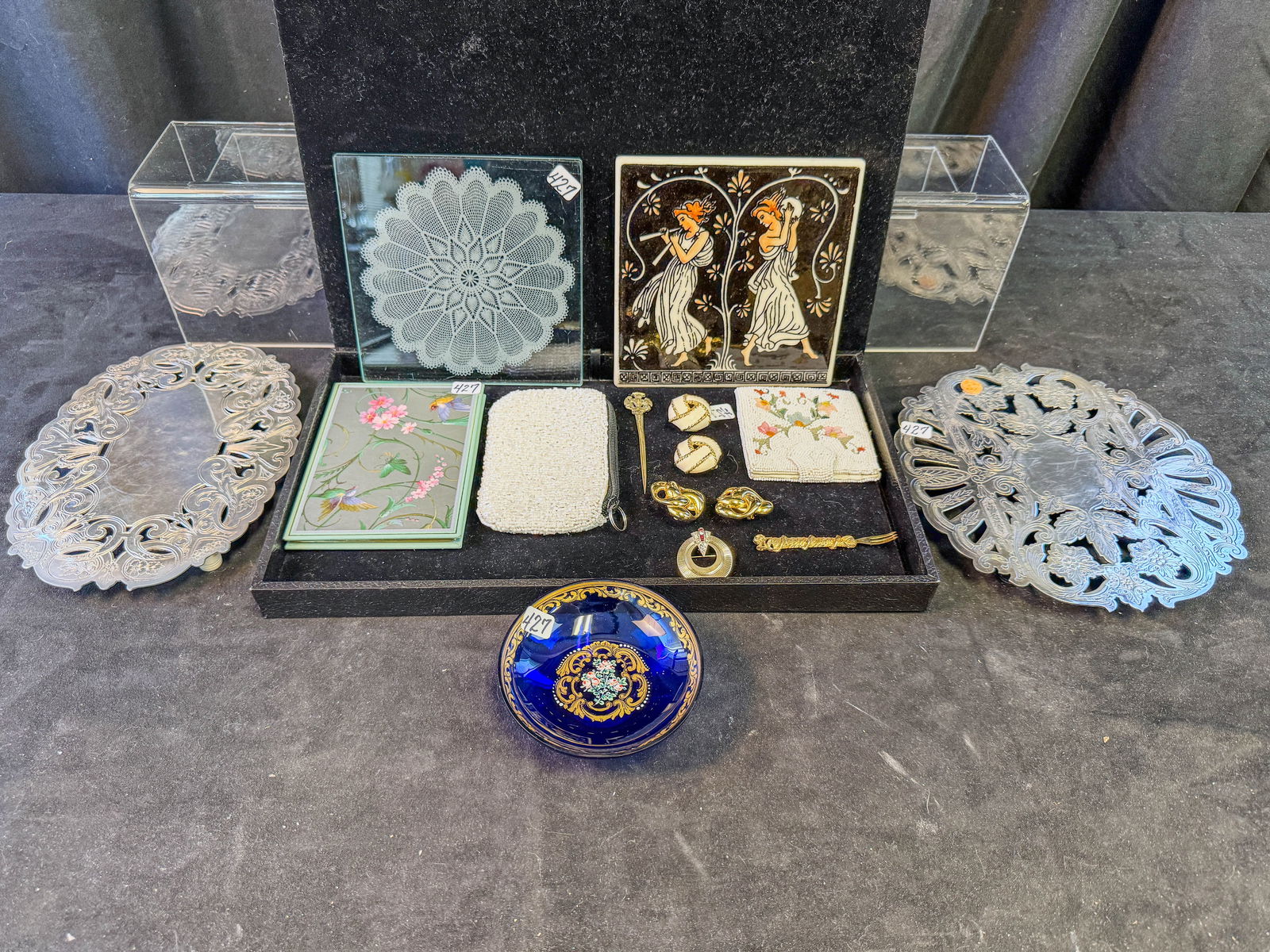 Bohemian Glass Tray, Saks Fifth Ave 1930s Beaded Wallet, Costume Jewelry and Trivets: A cobalt Bohemian hand painted glass tray, 2 beaded wallets, group of costume jewelry to include Cinder clip on earrings and collapsable photo album. One of the beaded wallets dates to the 1930s and i
