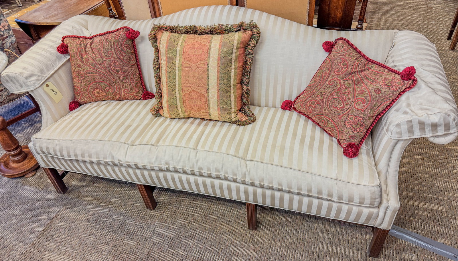 Camel-back Mahogany Trimmed Sofa in White and Cream Stripes: A Sherrill, down-filled sofa in white and cream stripes. This camel-back, mahogany trimmed piece comes with 3 cushions, has no staining and measures 36" tall X 84" across X 22" deep.