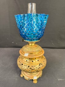 A Floral Pierced Brass Oil Lamp with a Blue Ruffled Edge Hobnail Shade