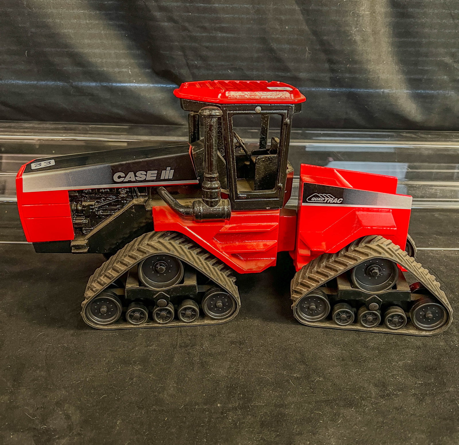 Ertl Case IH Quad Track Die Cast Metal 1/8 Scale. c.1990's: This Ertl 1/8 scale red metal die cast Case IH Quadtrac Tractor c. 1990s is in excellent condition. It has a detailed metal body and rubber treads. It measures 9" tall X 18" long X 7" across.