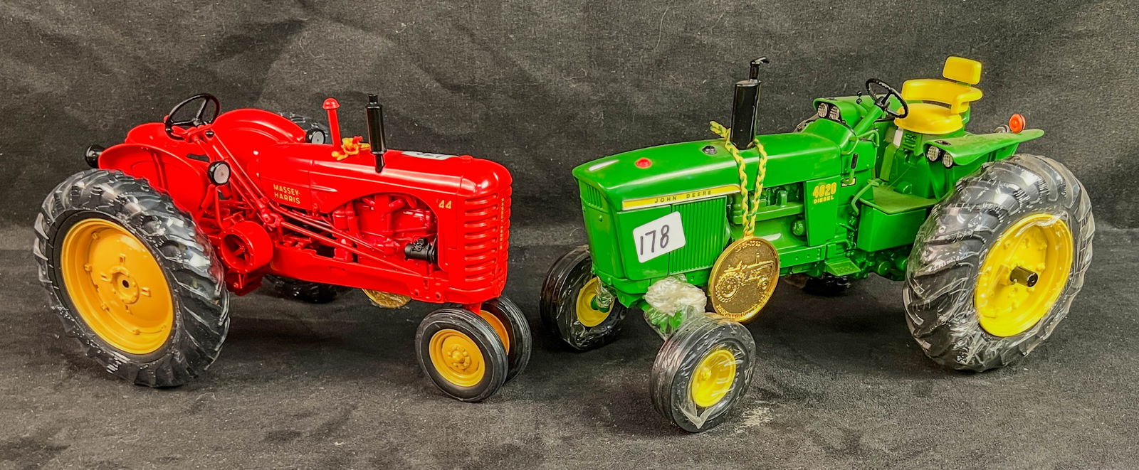 2 Ertl Precision Classic 1/16 Scale Die Cast Tractors, John Deere Model 4020 and a Massey Harris MH: 2 Ertl Precision Classic 1/16 Scale Die Cast Tractors to include a John Deere Model 4020 and a red Massey Harris MH 44 tractor both with their gold precision coins and factory wrapped wheels.