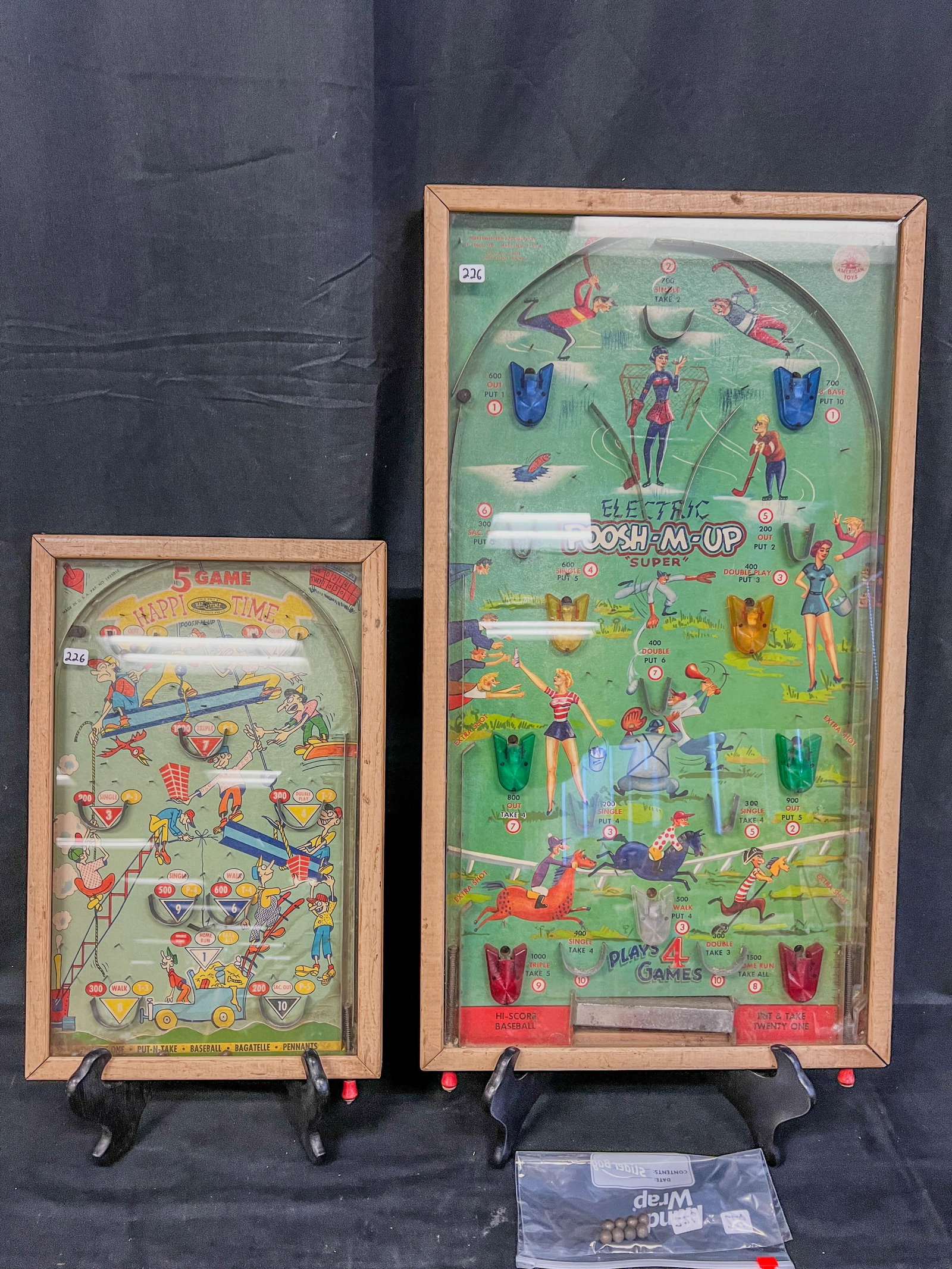 2 Vintage Pinball Games c.1940/50's: A lot of 2 vintage pinball games to include an Electric Poosh-M-Up Super (game takes batteries but is untested) and a Happi Time pinball game. Larger game measures 27" tall X 15" across, smaller game 