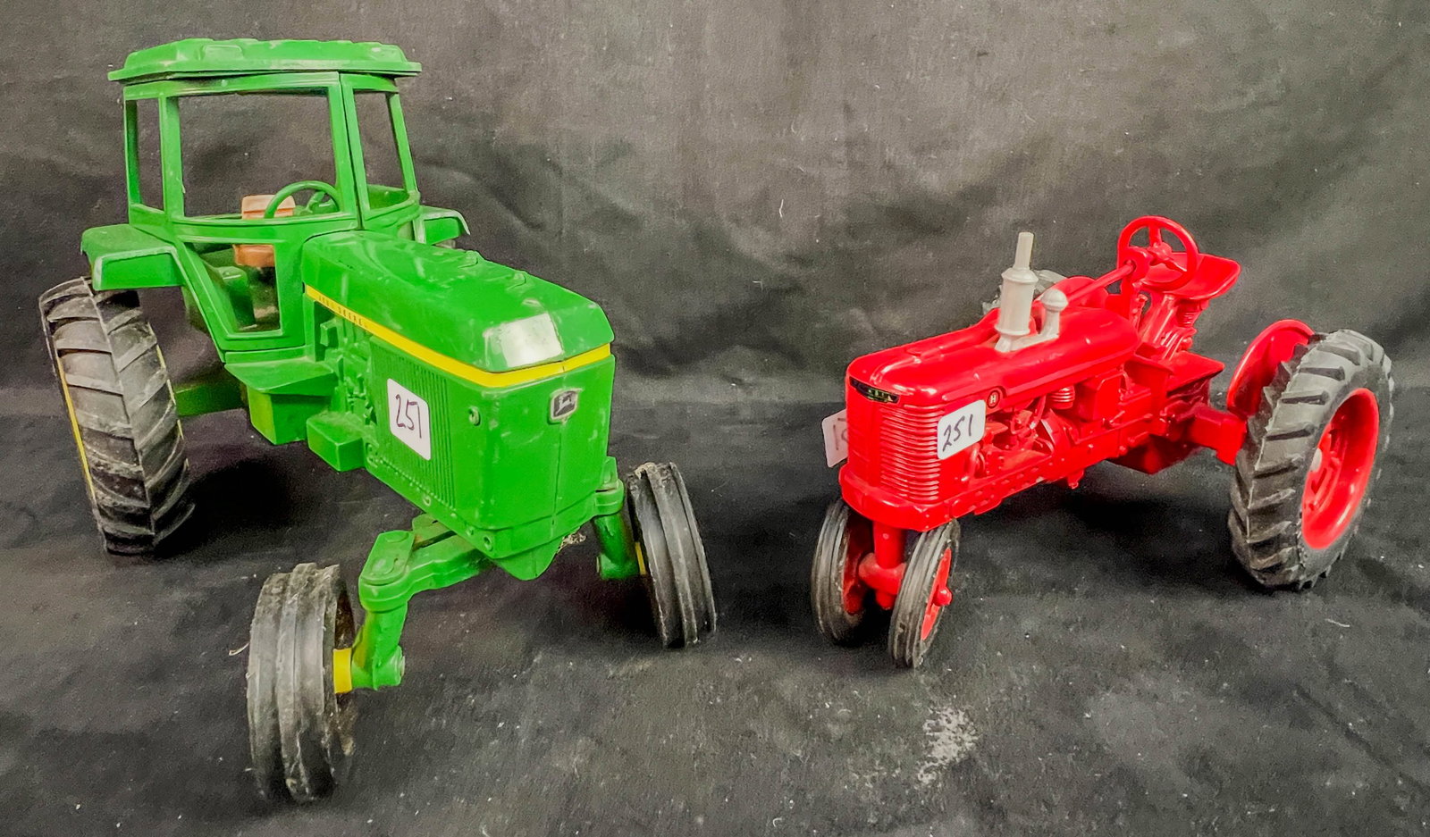 2 Ertl 1/16 Scale Die Cast Tractors, John Deere 4430, Farmall H: 2 Ertl 1/16 Scale Die Cast Tractors to include a green John Deere 4430 tractor with cab 9some paint loss to top oif cab and edges noted), and a red Farmall H tractor c.1986, very gently played with wi