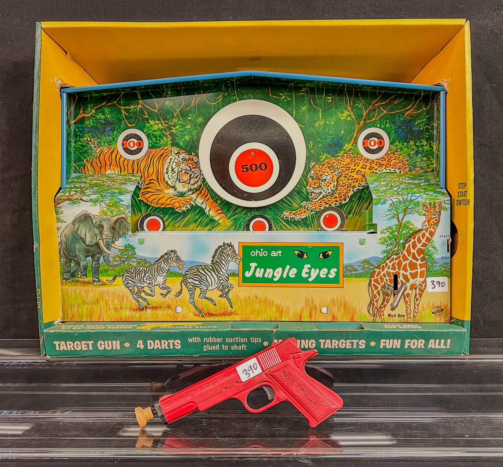 Ohio Arts Jungle Eyes Tin Litho Keywind Carnival Game in original box c1960's: An Ohio Arts Jungle Eyes tin litho clockwork kewywind carnival game in original box with gun, early 1960's. The elastic strap is very loose, and the clockworks work but need some lubrication. Box and 