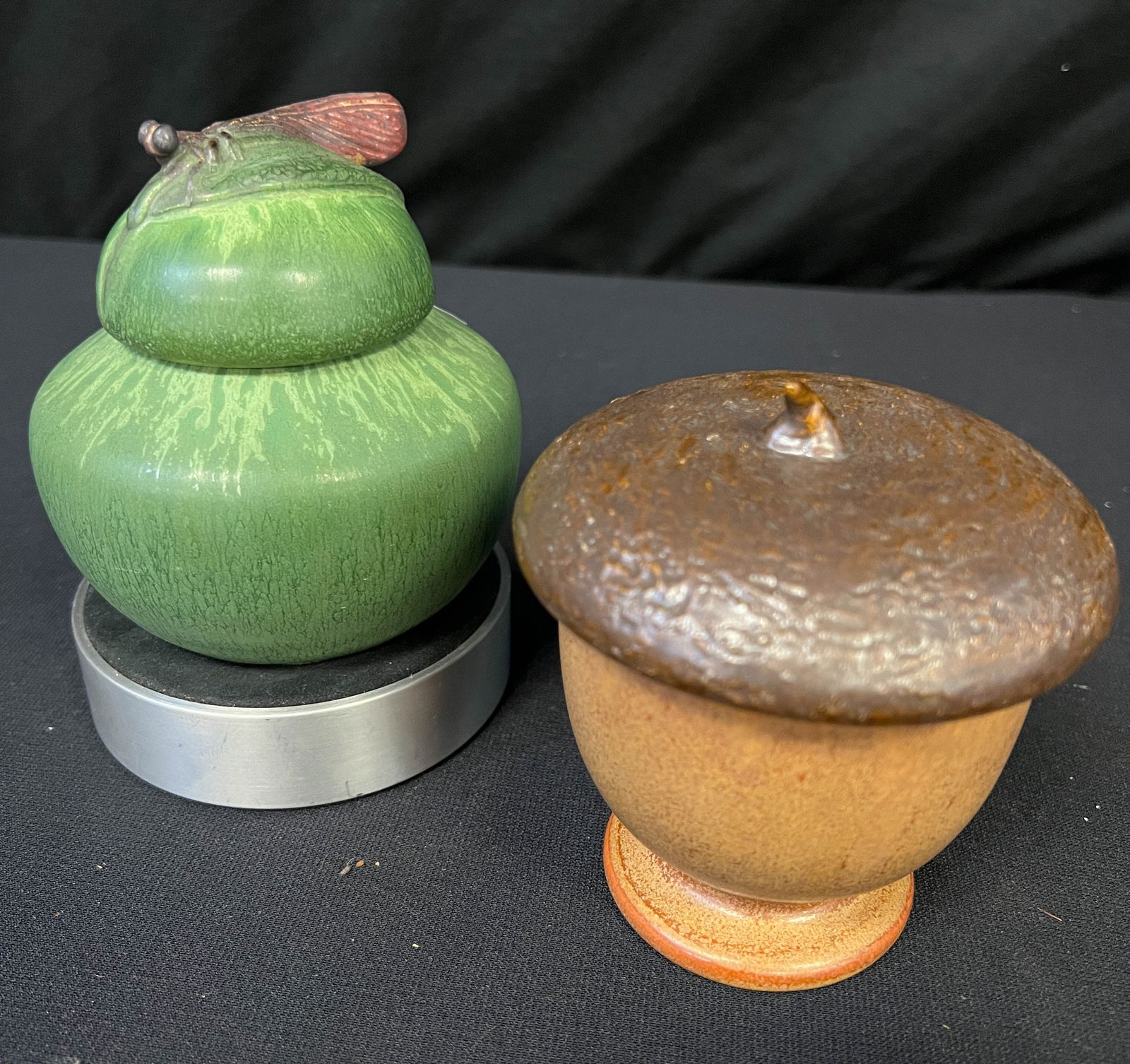 Two Mission Arts and Crafts Style Ephraim Covered Pottery Pieces: Ephraim lidded acorn jar. 147 made retired 2015. Signed Ephraim pottery, KH,KH. It measures 4" tall x 4" wide. Secondly, a Ephraim damselfly box. Artist signed Ephraim Pottery signed. 103 made retired