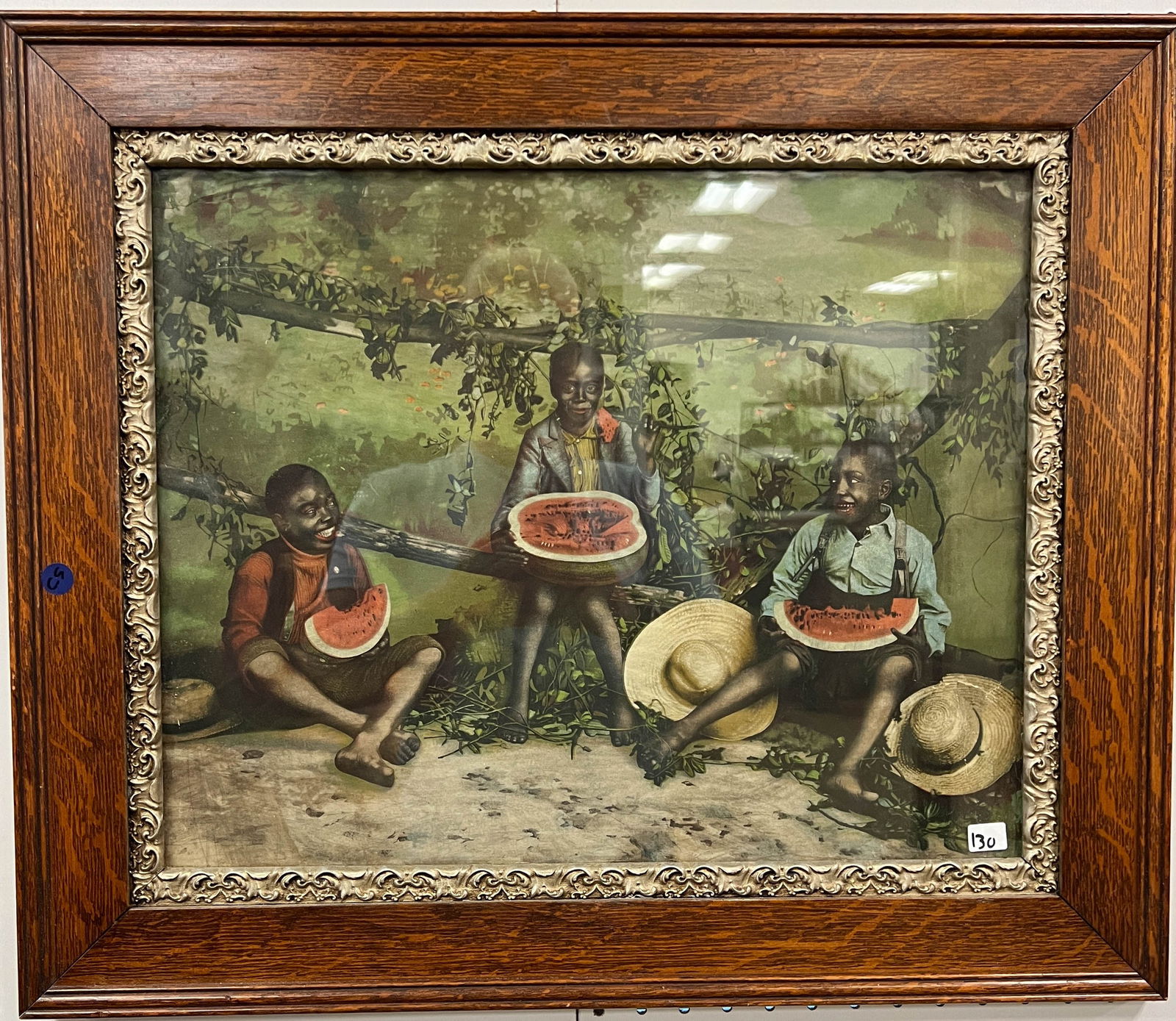 Framed Oak and Fancy Gesso Frame Depicting Three Black Children: Black Memorabilia steel lithograph hand color depicting three black children eating watermelon in a woodland scene. It is in excellent condition and it measures 22.5" tall x 26" wide.