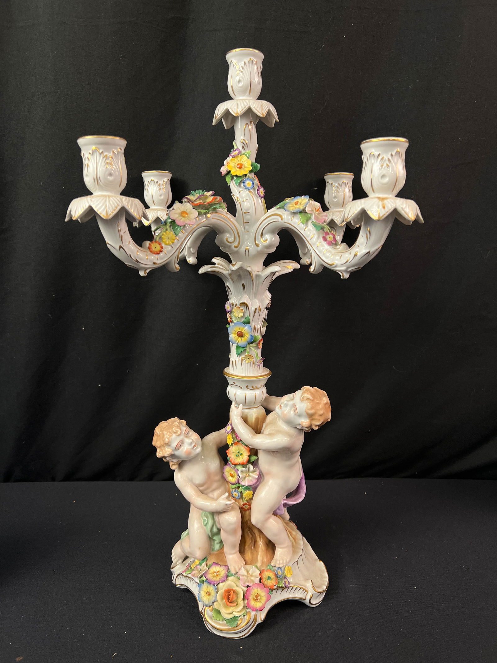 Antique Monumental Dresden Five Arm Candelabra: An antique monumental Dresden hand made five arm candelabra with putti, garland flowers and Roccoco accents. This high quality putti and floral decorated five arm candelabra is in excellent condition