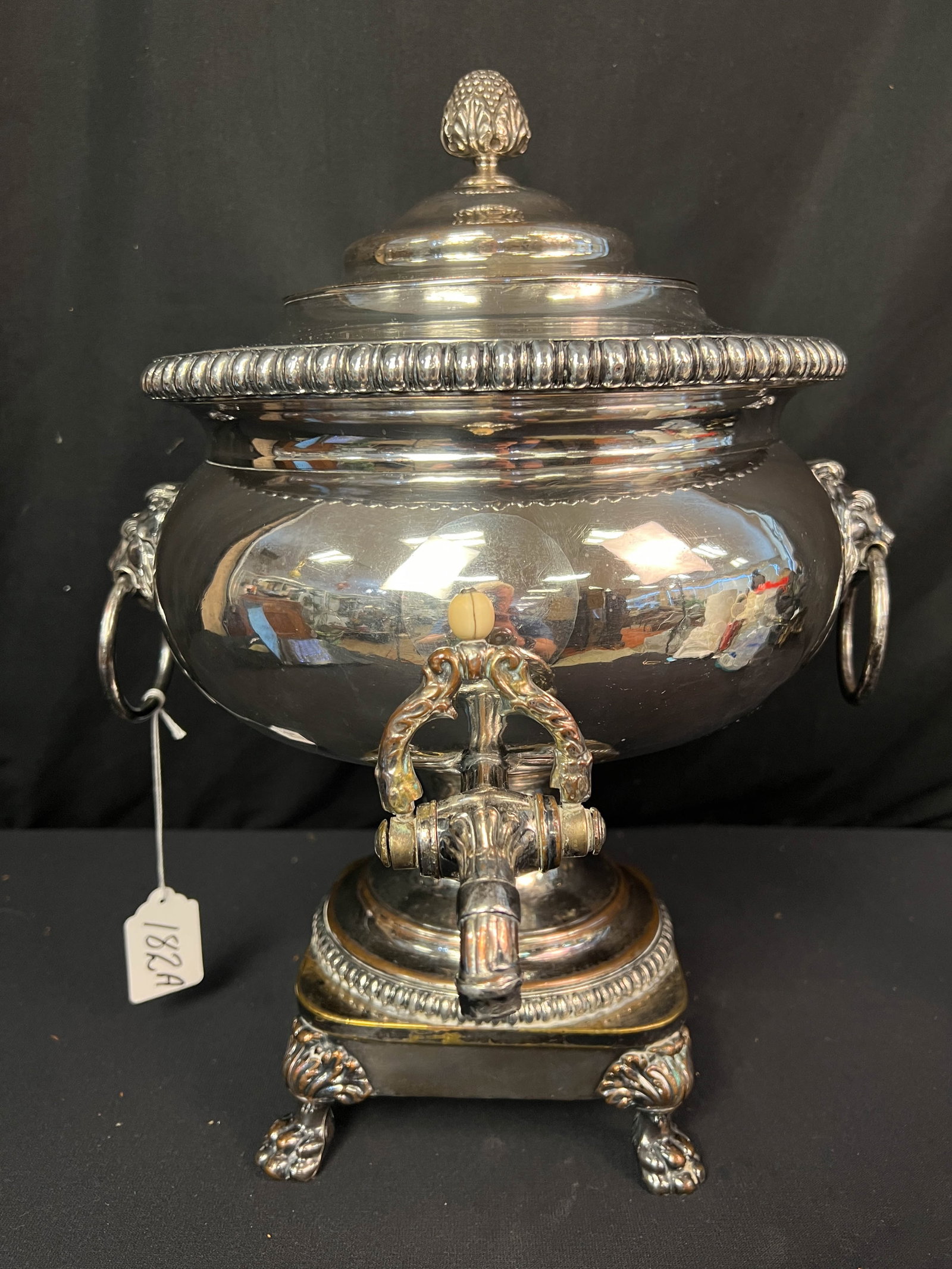 An 18th Century English Silver Over Copper Hot Water Dispenser: An 18th century silver plate hot water dispenser with lion headed handles, fancy spigot, and an elaborate finial cover. This early English hot water dispenser is in great working condition and it meas