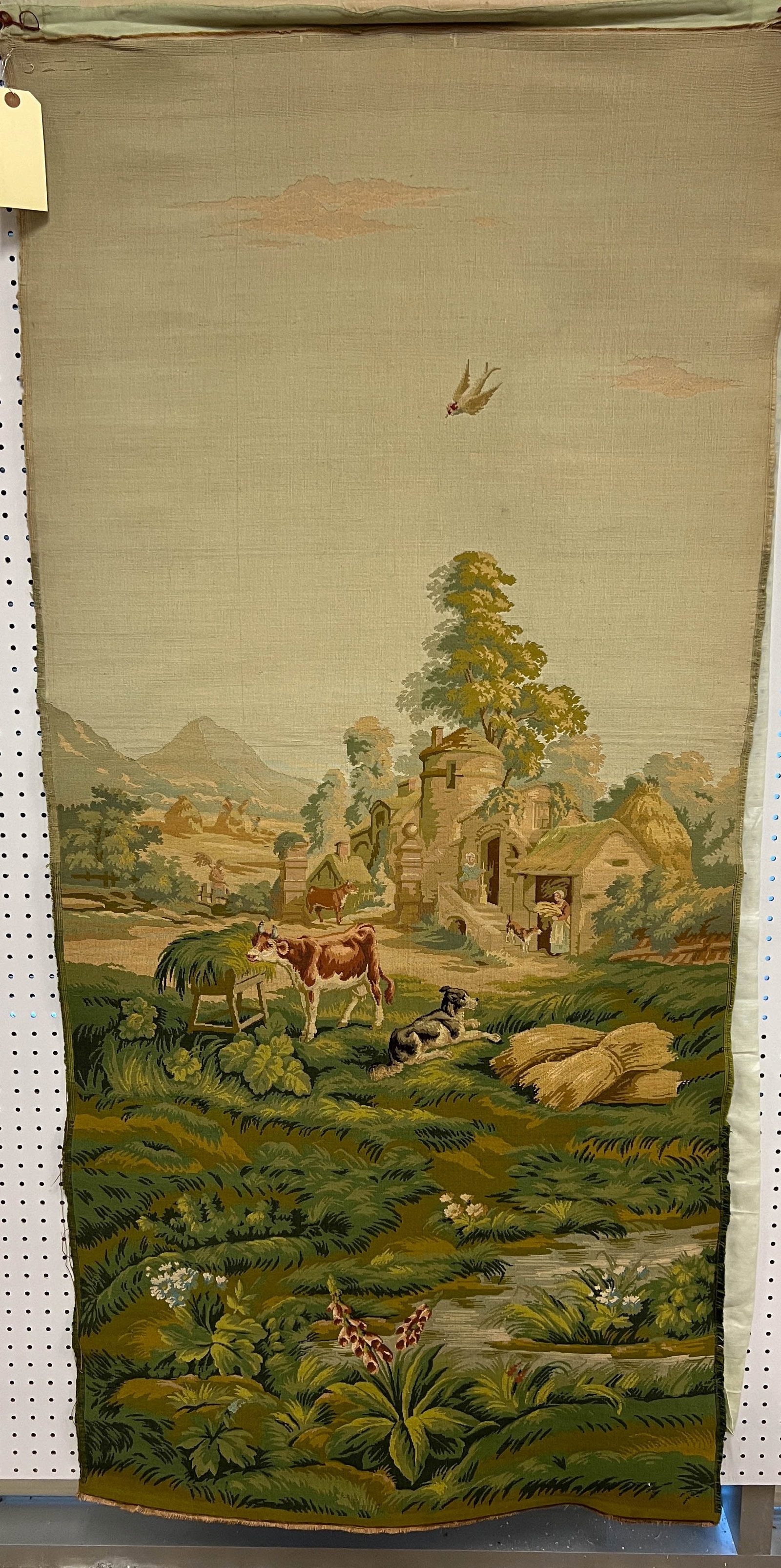 An Aubusson Fine Woven Tapestry: A finely woven Aubusson tapestry depicting a French country farm with flowers, animals, peasants, and a cottage. This antique tapestry retains much of its original color and measures 66" x 35".