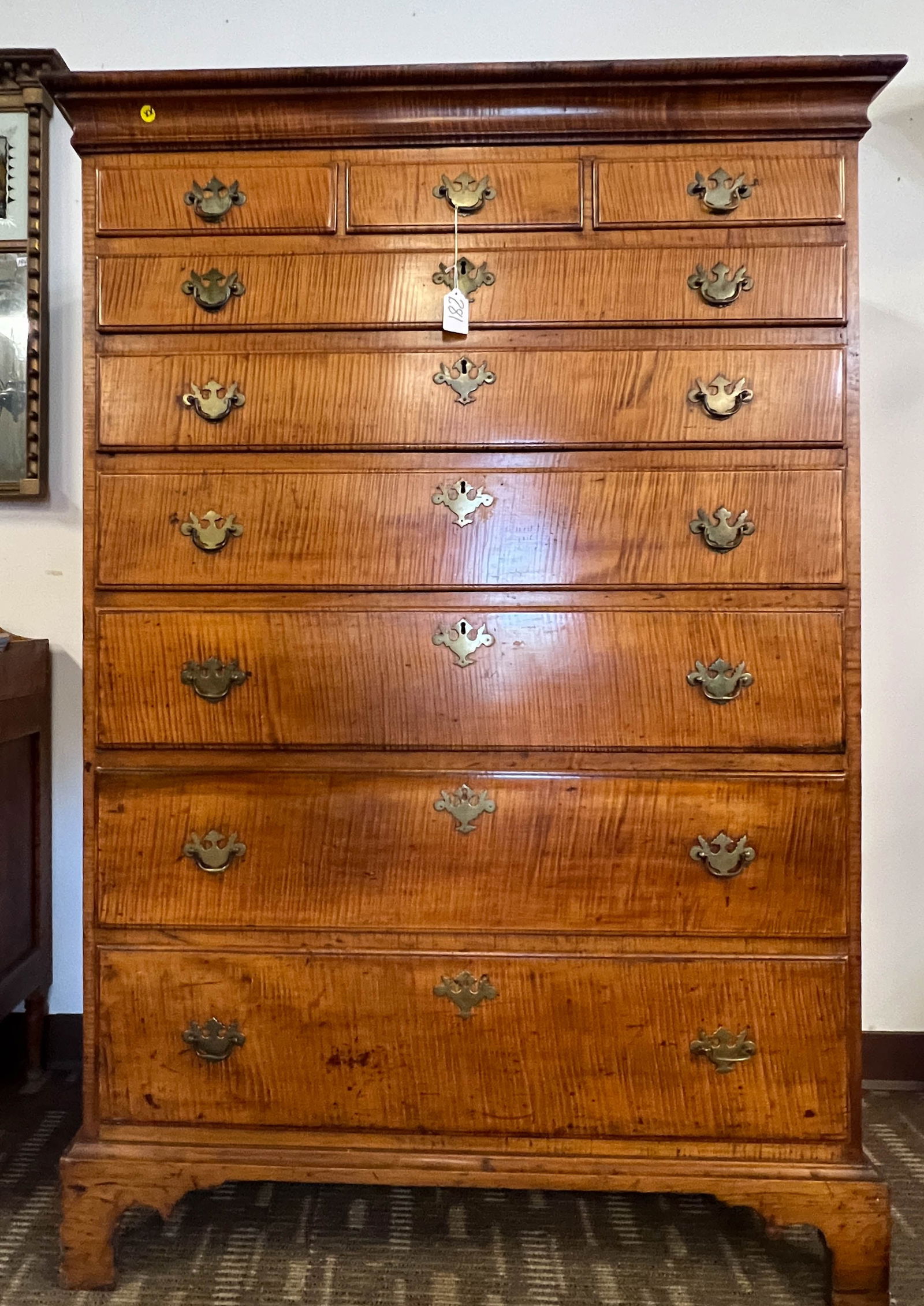 18th Century Eastern Highboy In Tiger Stripe Maple: An 18th Century Eastern Highboy In Tiger Stripe Maple that retains its original finish and hardware. It has nine drawers on bracket feet, and it is in excellent condition. This stunning 18th century h